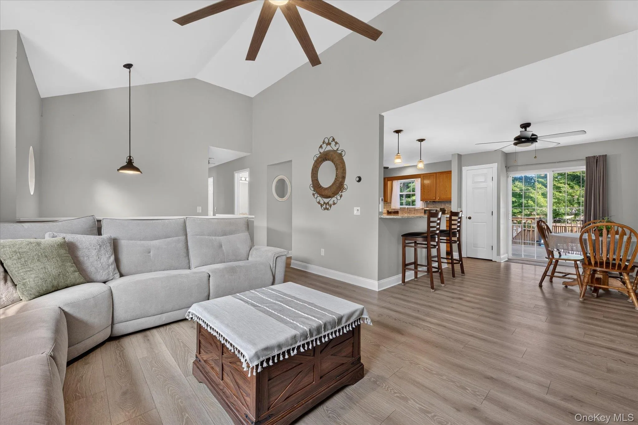Vaulted ceiling with a ceiling fan, recessed lighting, wood-finish flooring, and an open-concept layout Vaulted ceiling with a ceiling fan, recessed lighting, wood-finish flooring, and an open-concept layout