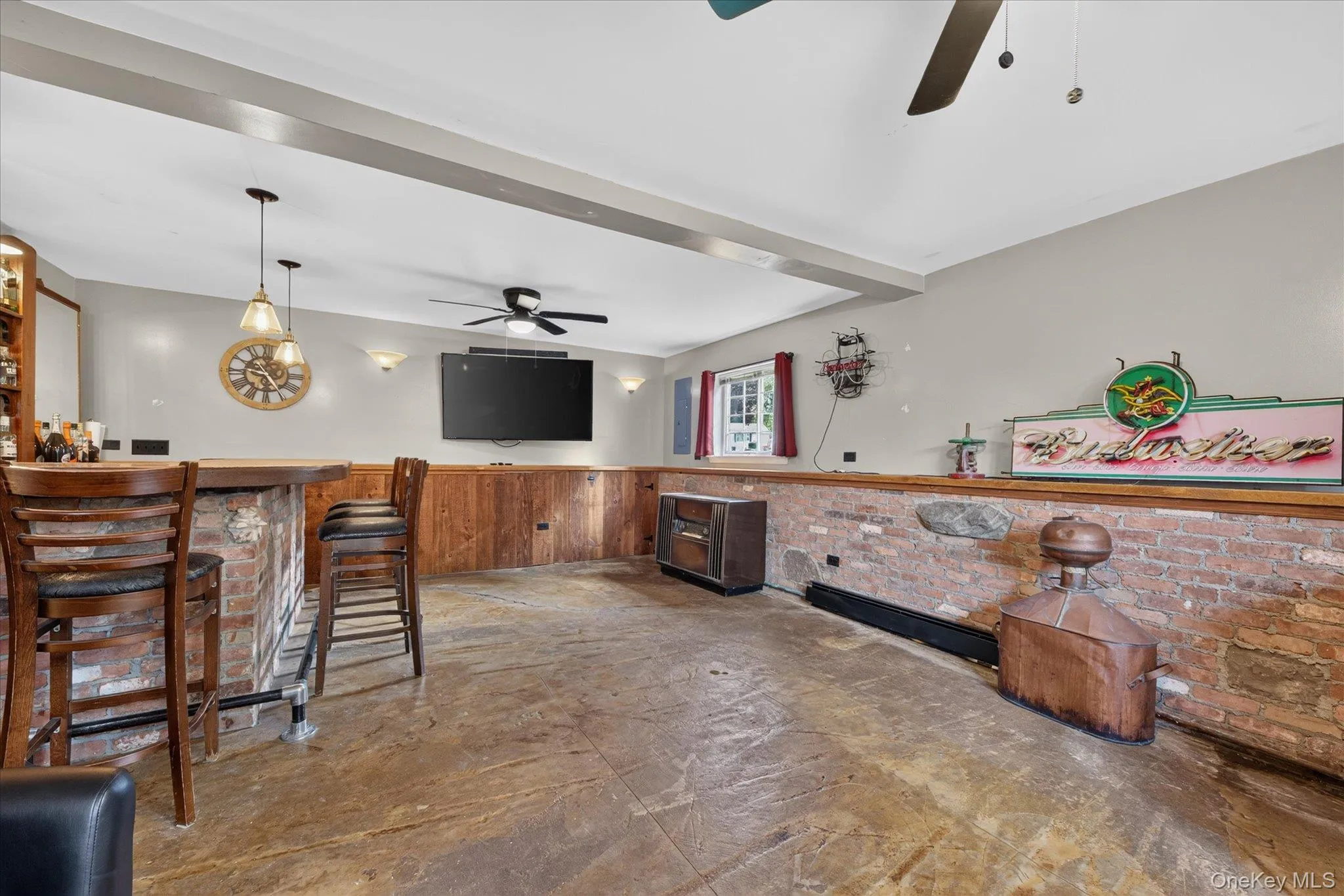 Finished basement with a built-in bar featuring a brick base, wood countertop, and pendant lighting Finished basement with a built-in bar featuring a brick base, wood countertop, and pendant lighting