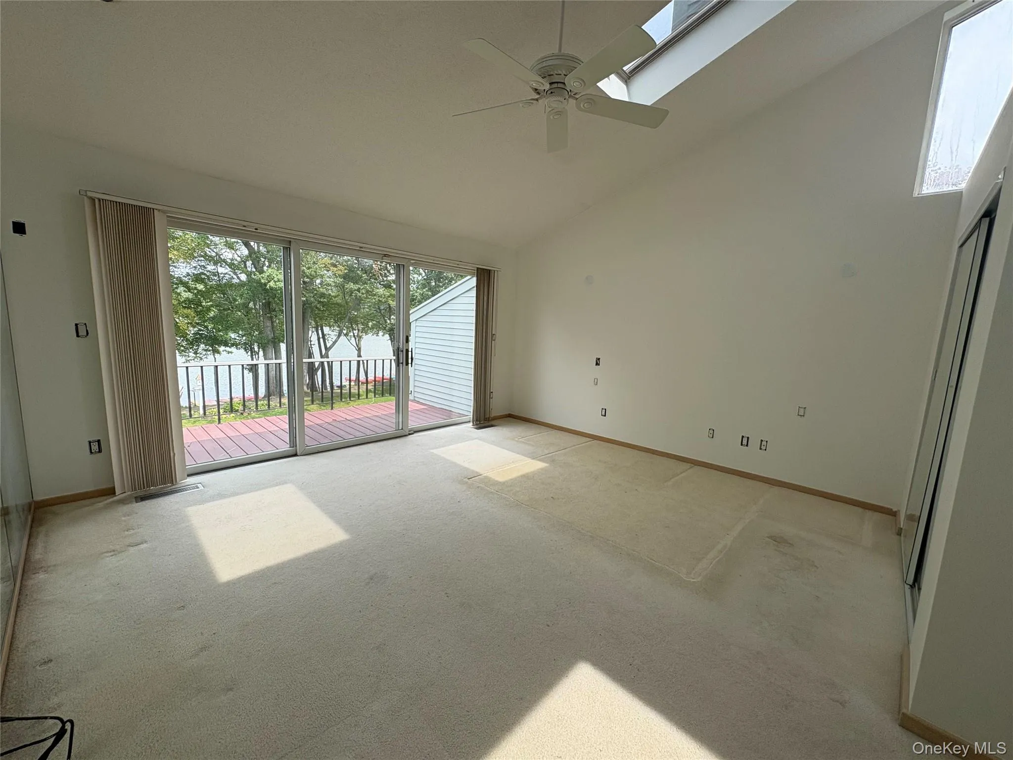 Primary Bedroom has cathedral ceiling & sliding glass doors to private balcony w/ lake views Primary Bedroom has cathedral ceiling & sliding glass doors to private balcony w/ lake views