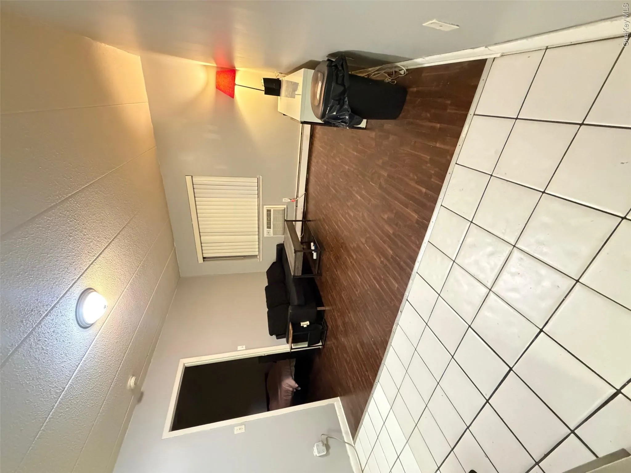 Living area with dark tile patterned floors and a baseboard heating unit Living area with dark tile patterned floors and a baseboard heating unit