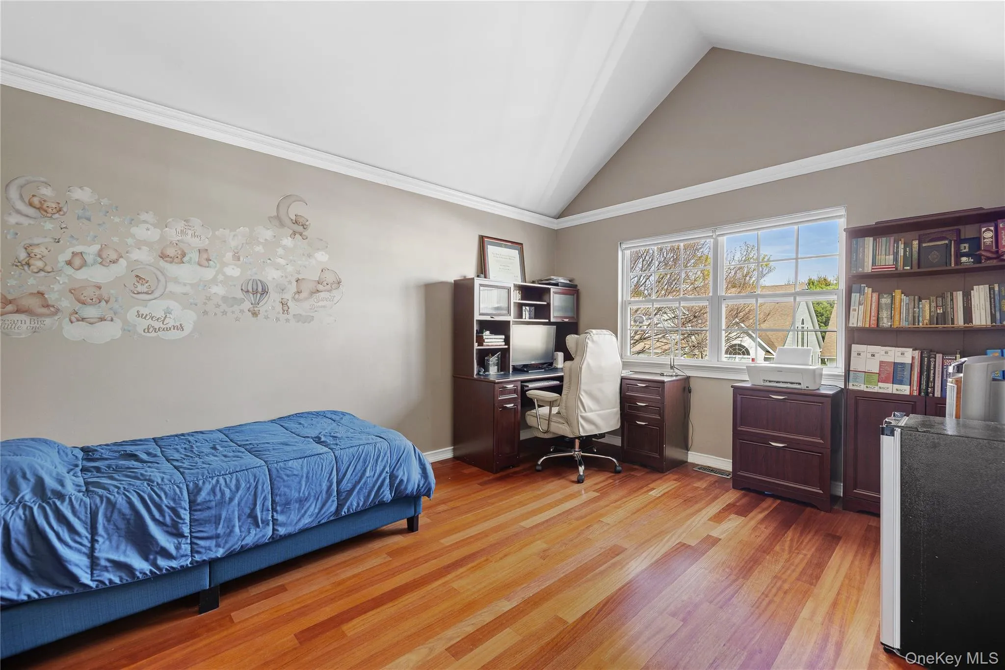 Upper Bedrm, vaulted ceiling with white crown molding, wood-finish flooring, and a large window Upper Bedrm, vaulted ceiling with white crown molding, wood-finish flooring, and a large window