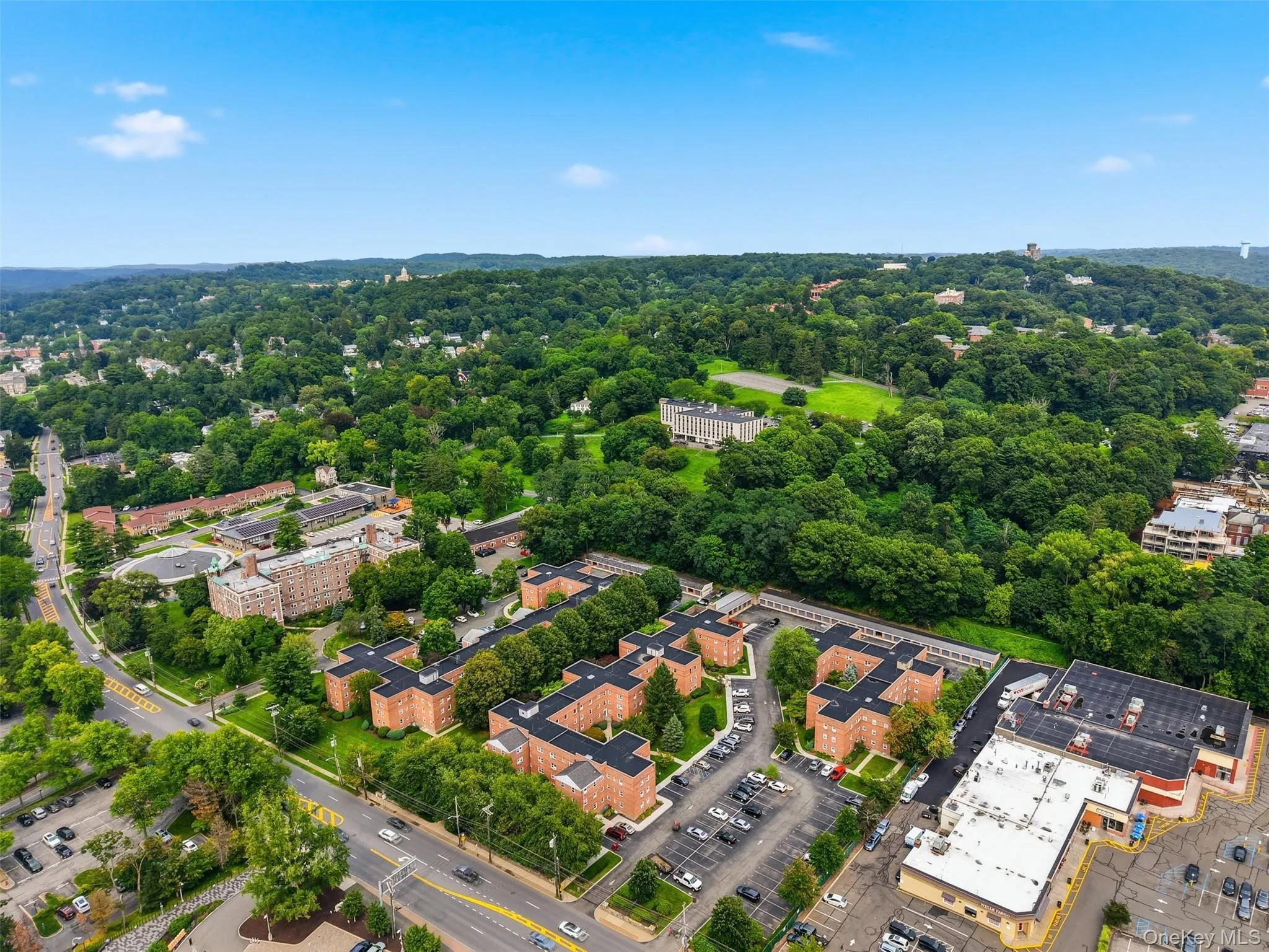 Bird's-eye view of the community, highlighting the classic brick buildings, lush green courtyards, and convenient location right on the main road. Bird's-eye view of the community, highlighting the classic brick buildings, lush green courtyards, and convenient location right on the main road.
