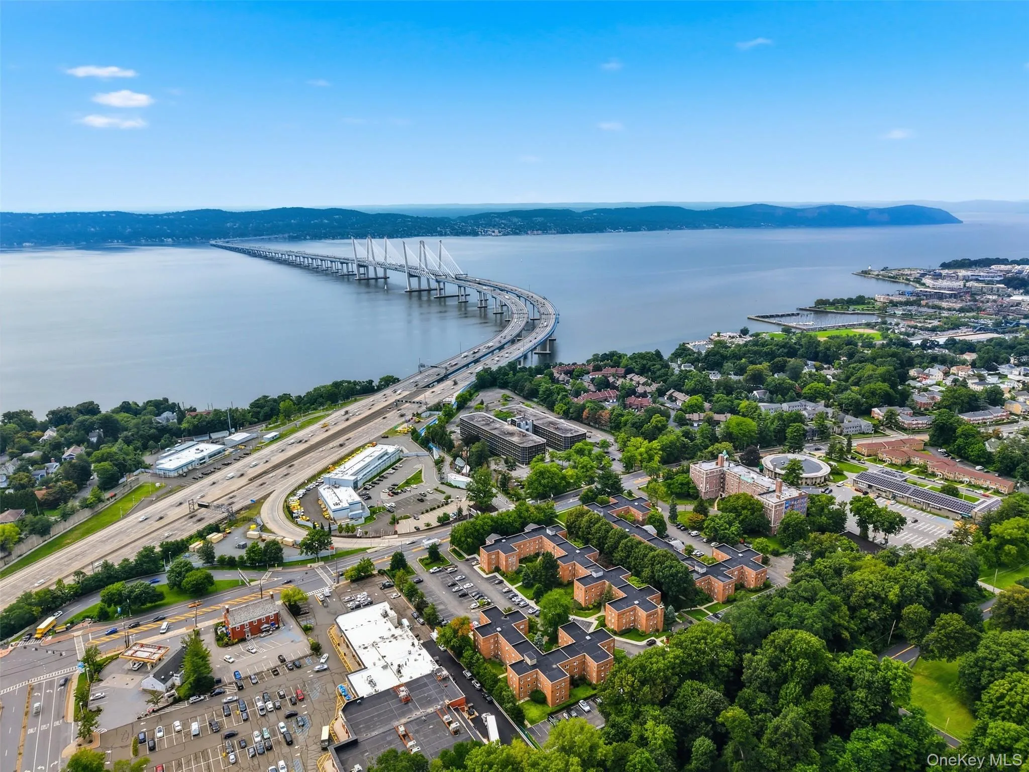 Fantastic bird's-eye view showcasing the expansive community grounds, well-maintained brick buildings, convenient on-site parking, and the stunning backdrop of the Hudson River and Mario M. Cuomo Bridge. Fantastic bird's-eye view showcasing the expansive community grounds, well-maintained brick buildings, convenient on-site parking, and the stunning backdrop of the Hudson River and Mario M. Cuomo Bridge.