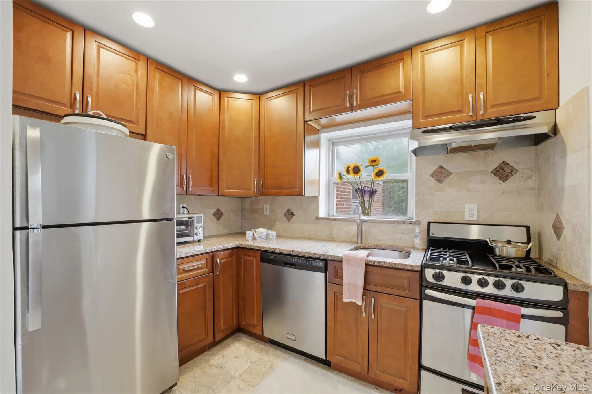 Well-equipped kitchen featuring warm wood cabinetry, stainless steel appliances, and stone countertops. Well-equipped kitchen featuring warm wood cabinetry, stainless steel appliances, and stone countertops.