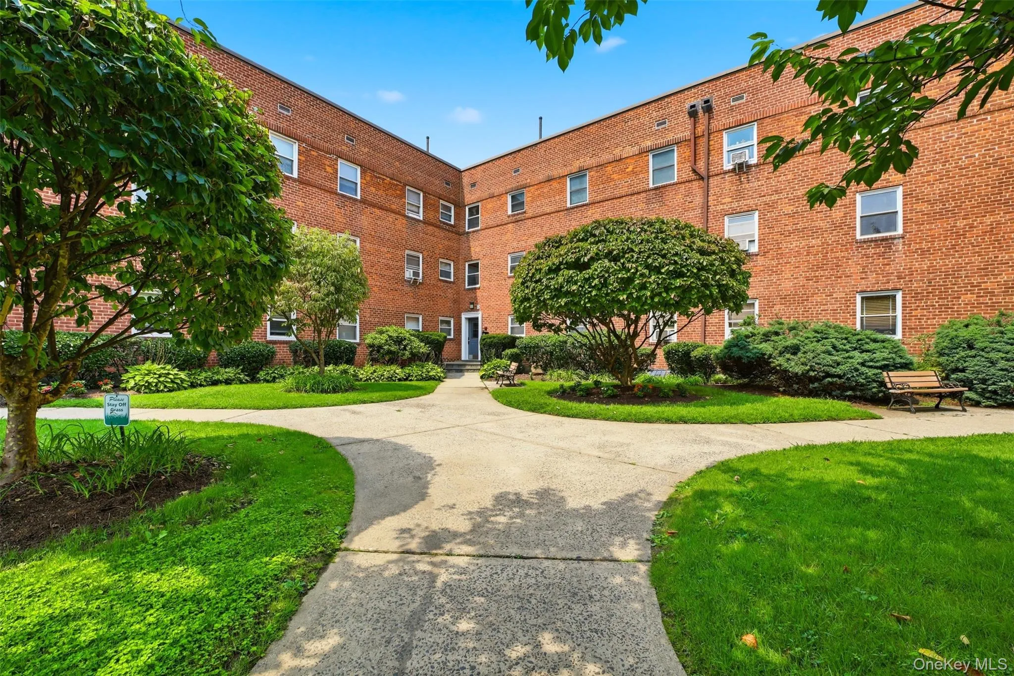 Well-maintained community courtyard with paved walkways and lush landscaping. Well-maintained community courtyard with paved walkways and lush landscaping.