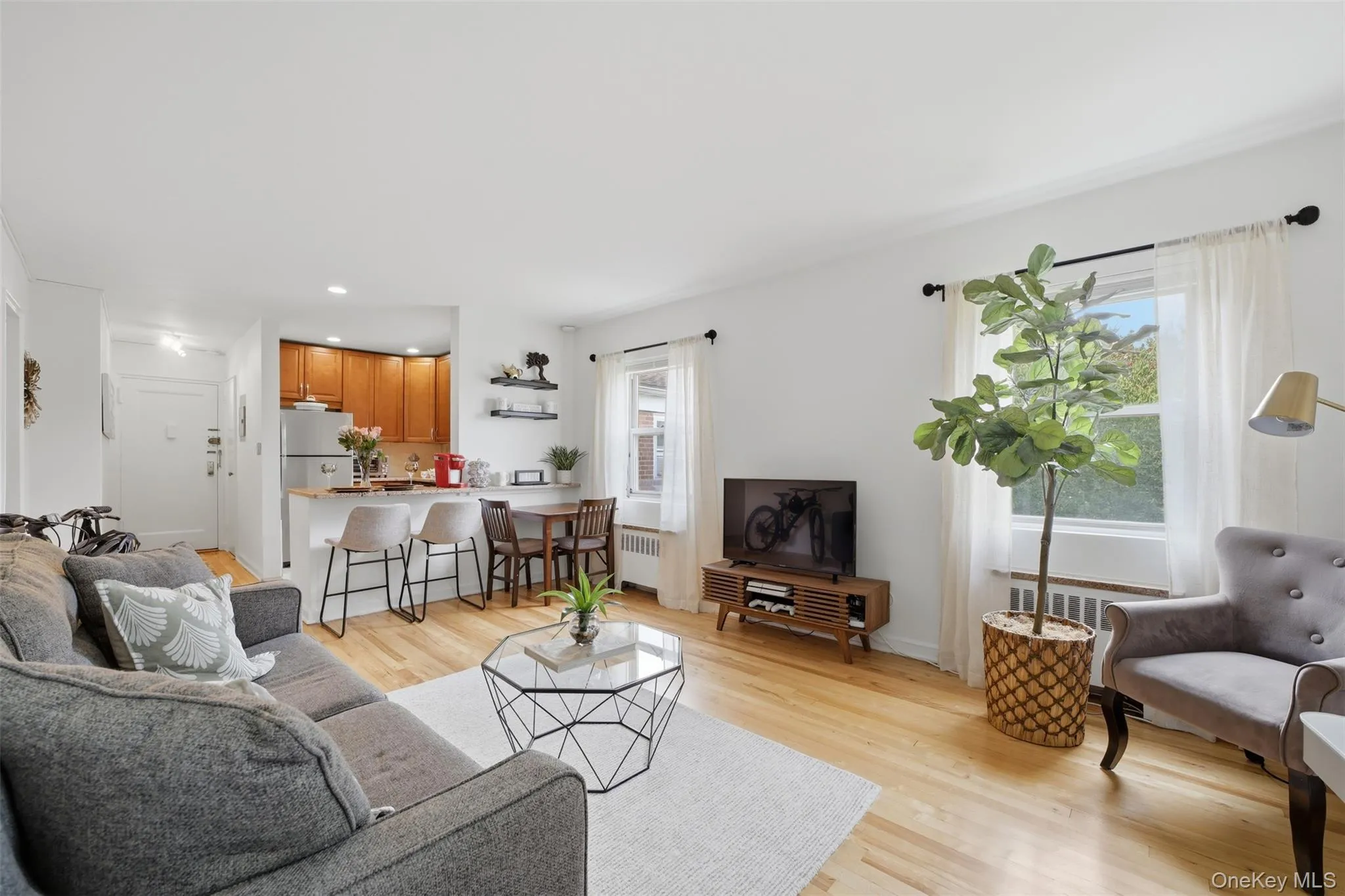 Bright and inviting open-concept living area with hardwood floors and abundant natural light. Bright and inviting open-concept living area with hardwood floors and abundant natural light.