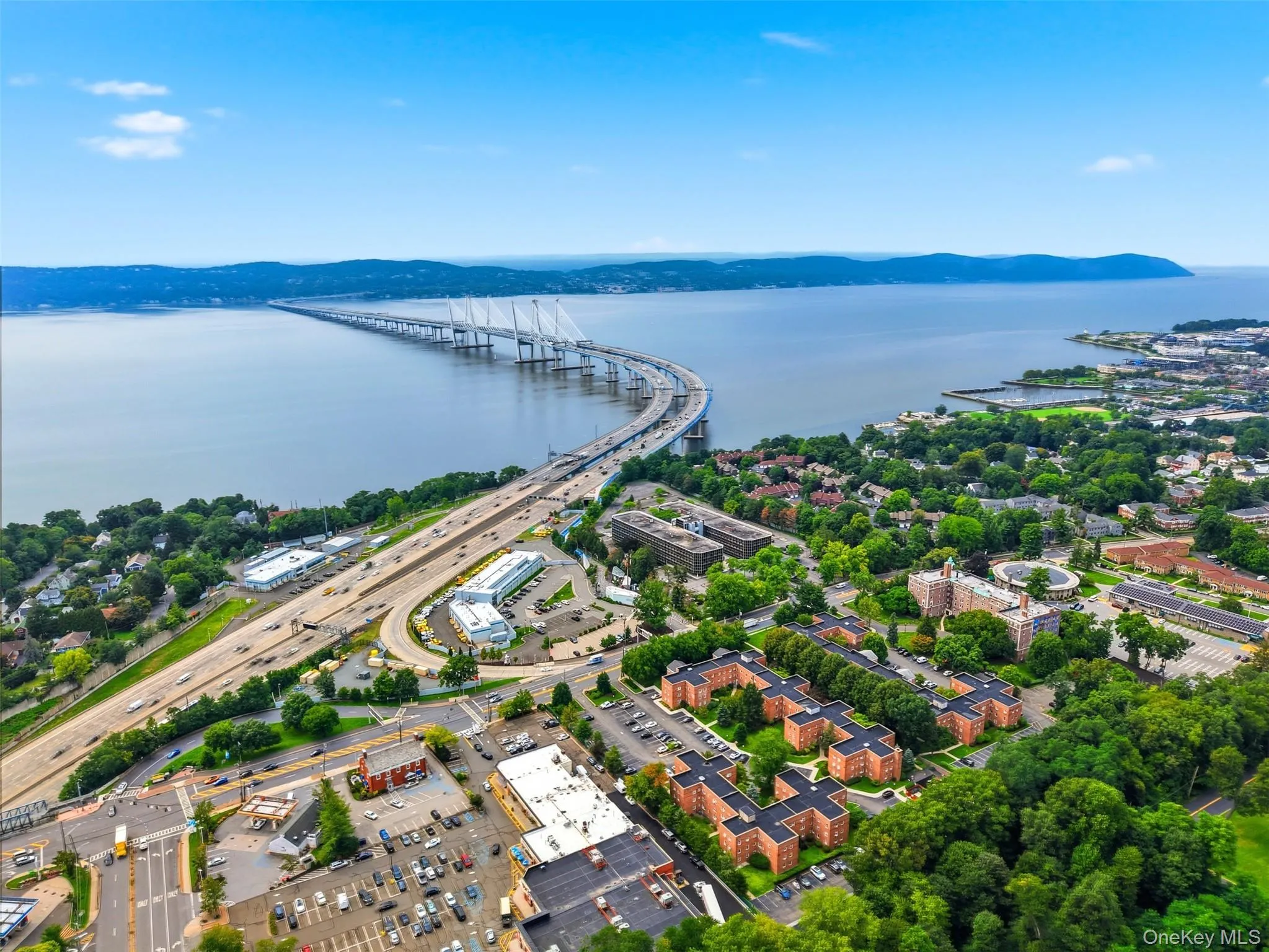 Fantastic bird's-eye view showcasing the expansive community grounds, well-maintained brick buildings, convenient on-site parking, and the stunning backdrop of the Hudson River and Mario M. Cuomo Bridge. Fantastic bird's-eye view showcasing the expansive community grounds, well-maintained brick buildings, convenient on-site parking, and the stunning backdrop of the Hudson River and Mario M. Cuomo Bridge.