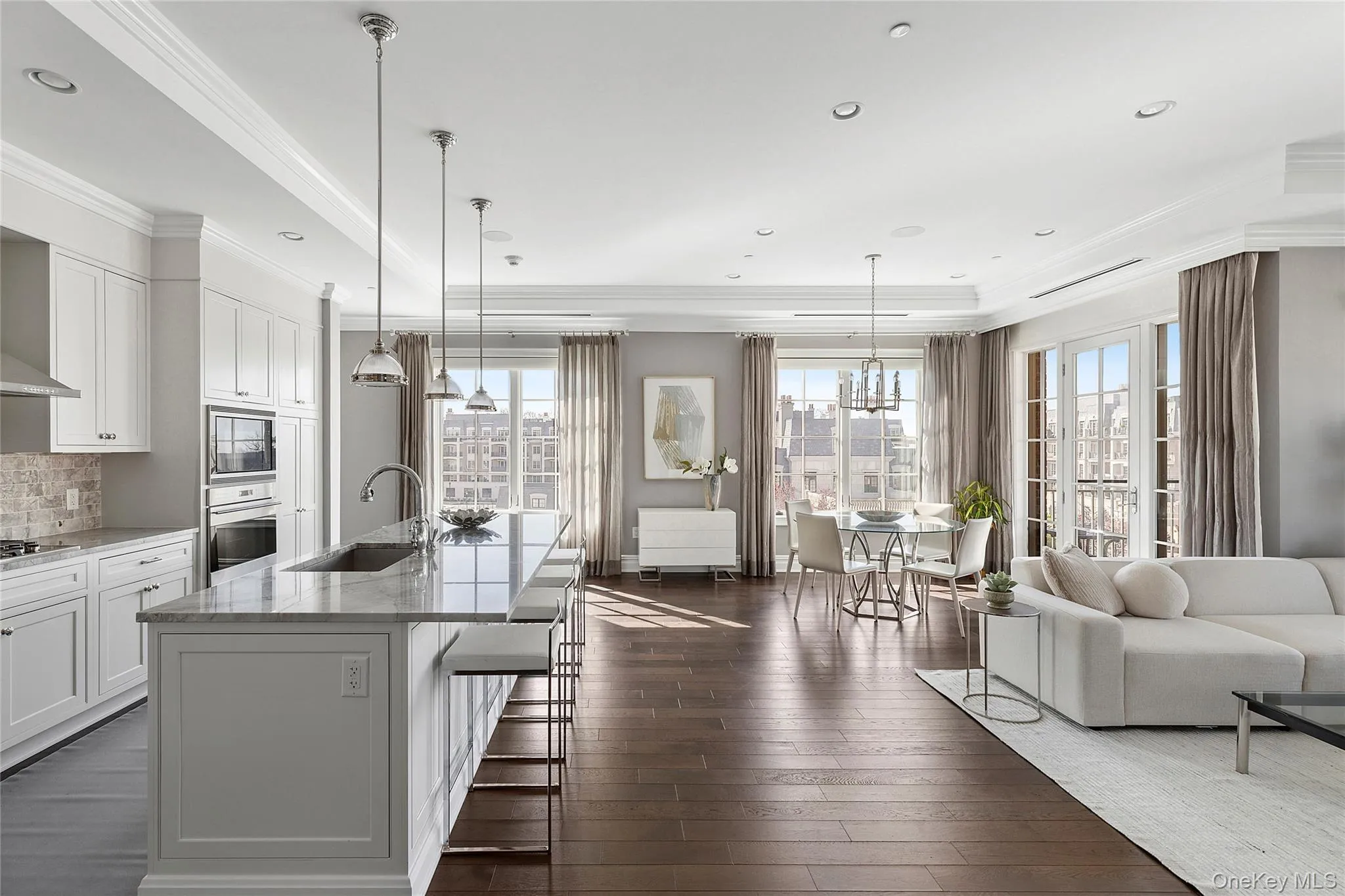 Kitchen featuring stainless steel appliances, ornamental molding, a sink, and a healthy amount of sunlight Kitchen featuring stainless steel appliances, ornamental molding, a sink, and a healthy amount of sunlight