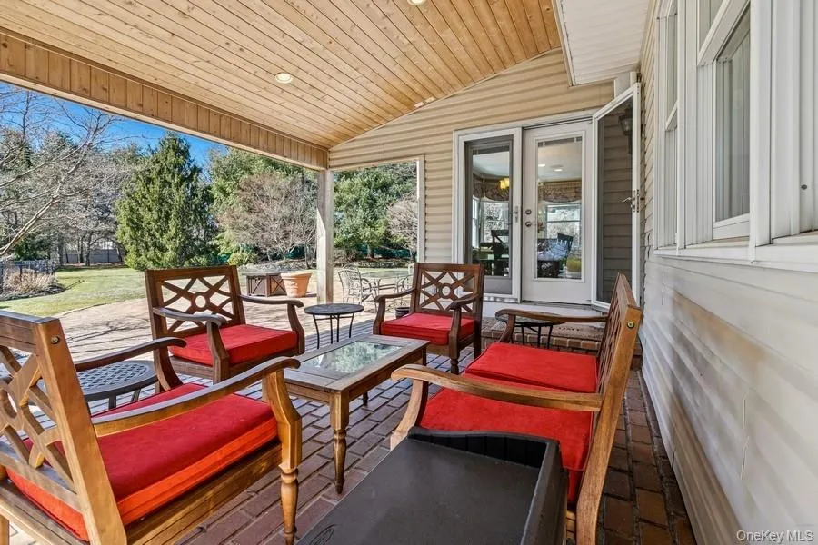 Covered patio overlooking country club yard with freeform mountain lake pool Covered patio overlooking country club yard with freeform mountain lake pool