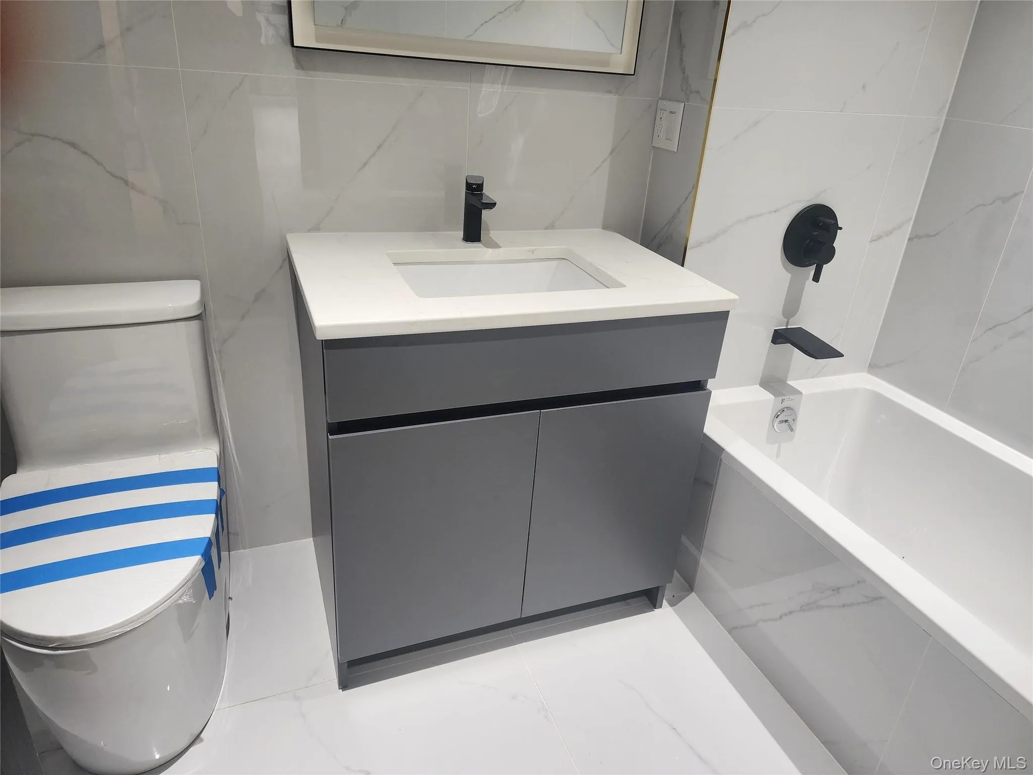 White tiled walls and flooring with subtle veining White tiled walls and flooring with subtle veining