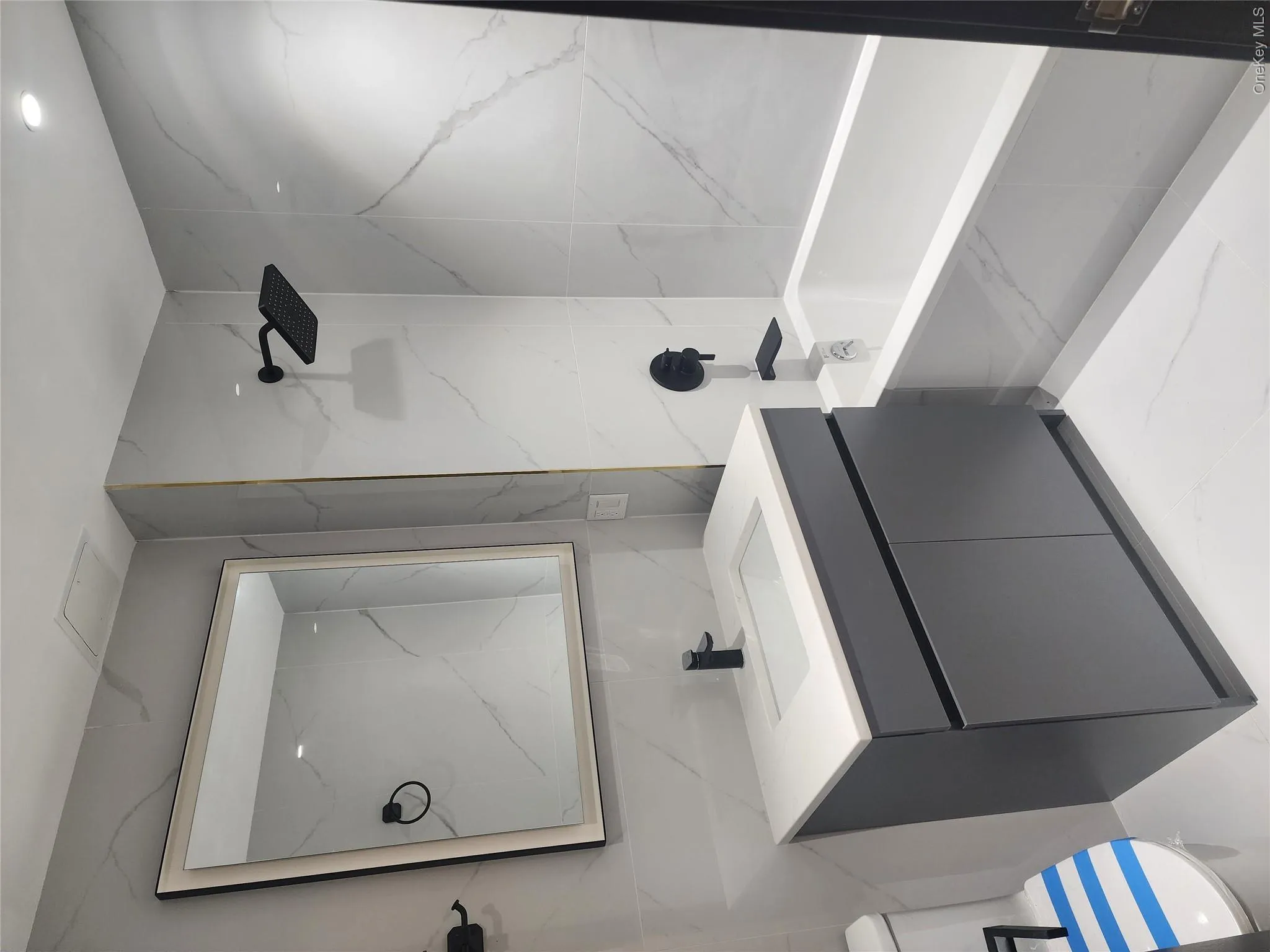 Bathroom featuring a deep soaking tub, rain shower head, matte black fixtures, integrated sink, and a gray vanity with enclosed storage Bathroom featuring a deep soaking tub, rain shower head, matte black fixtures, integrated sink, and a gray vanity with enclosed storage