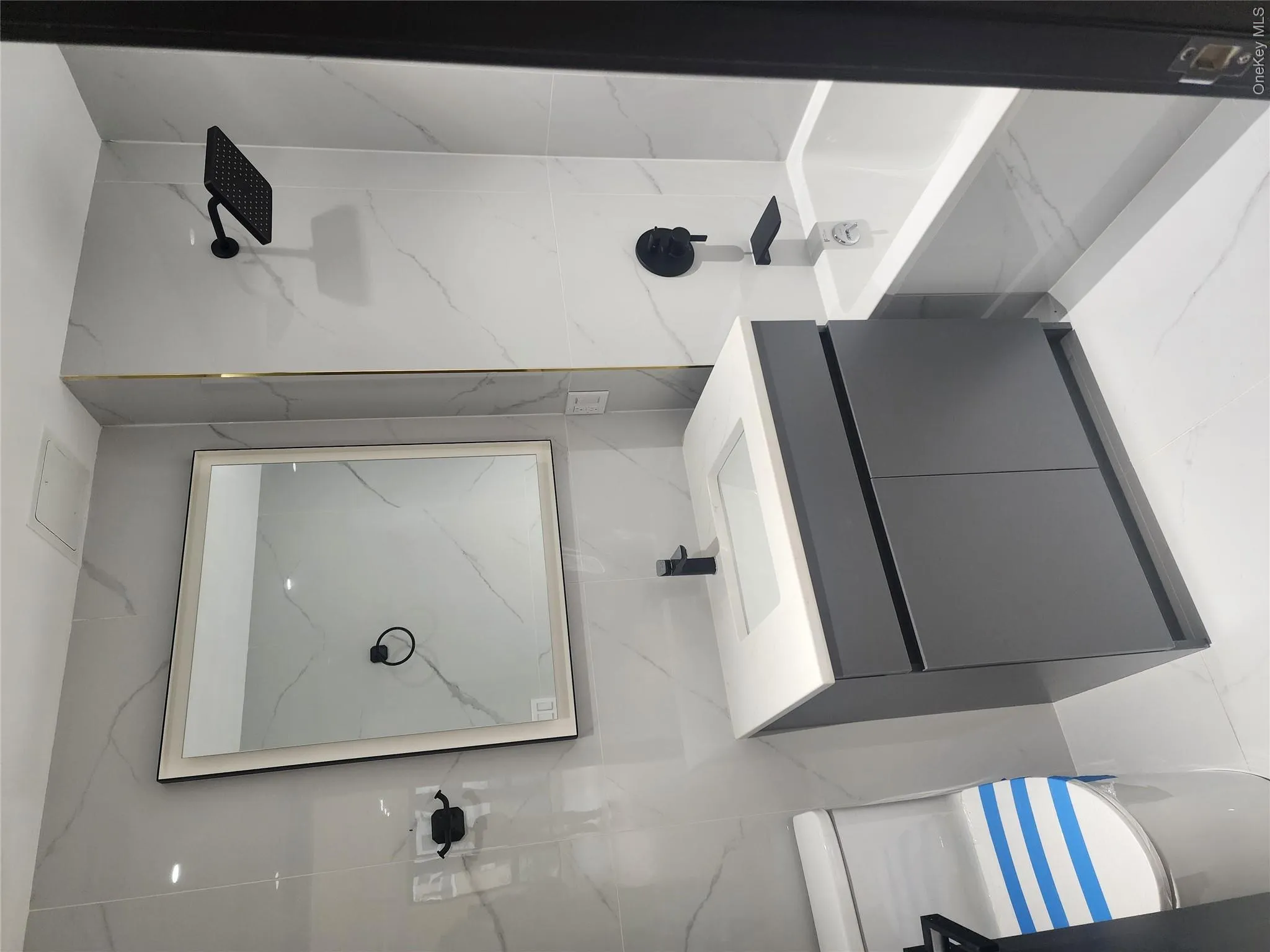 White tiled bathroom with gray vanity and integrated sink White tiled bathroom with gray vanity and integrated sink