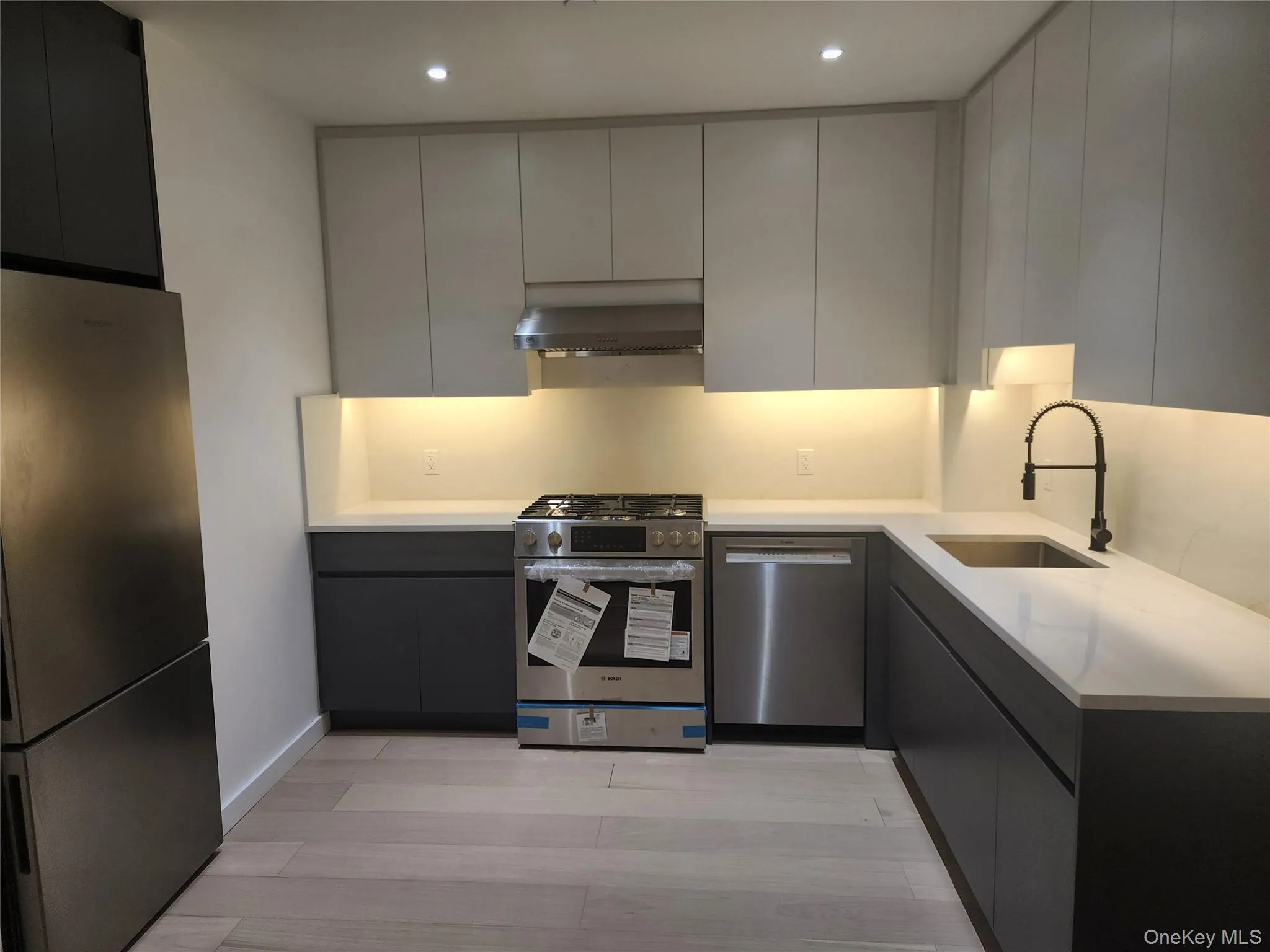 Modern kitchen featuring light gray upper cabinetry and dark gray lower cabinetry Modern kitchen featuring light gray upper cabinetry and dark gray lower cabinetry