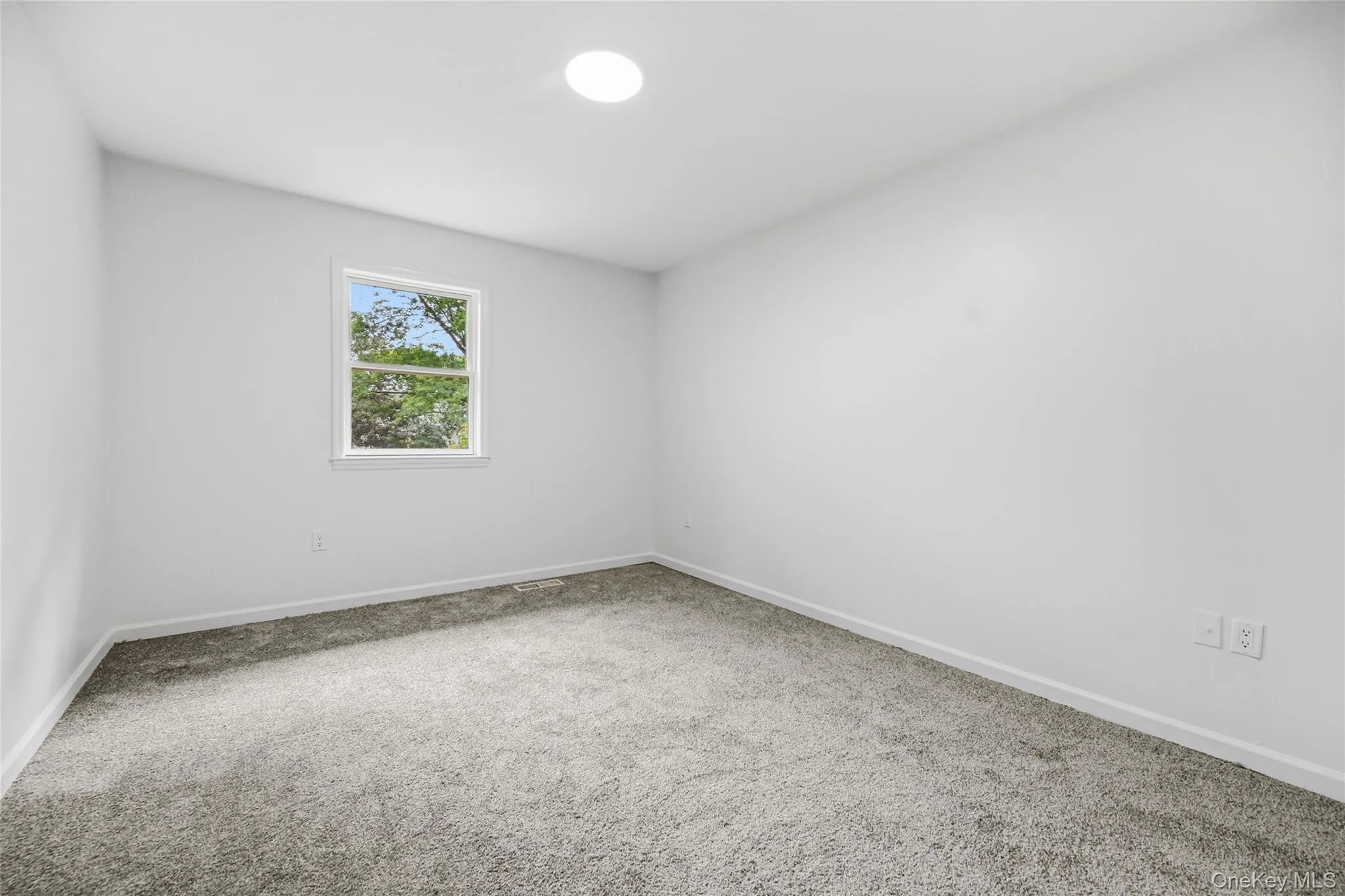 Recessed ceiling lighting, light gray wall finish, single window, and gray carpet flooring Recessed ceiling lighting, light gray wall finish, single window, and gray carpet flooring