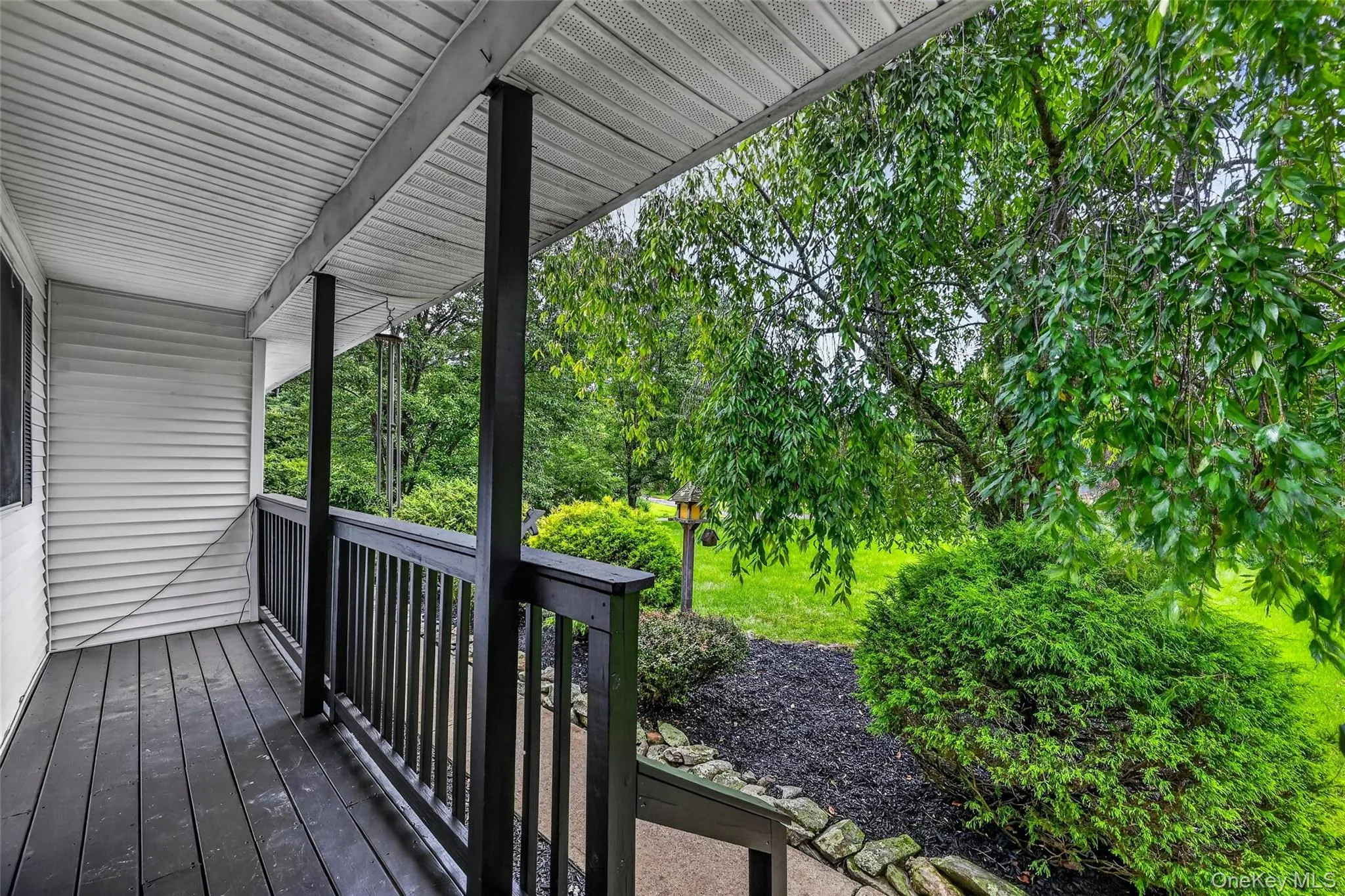 Covered porch with dark wood-finish decking and railing Covered porch with dark wood-finish decking and railing