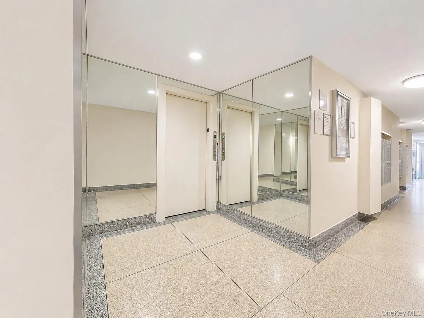 Mirrored wall panels, terrazzo flooring, recessed lighting, and a neutral color palette Mirrored wall panels, terrazzo flooring, recessed lighting, and a neutral color palette