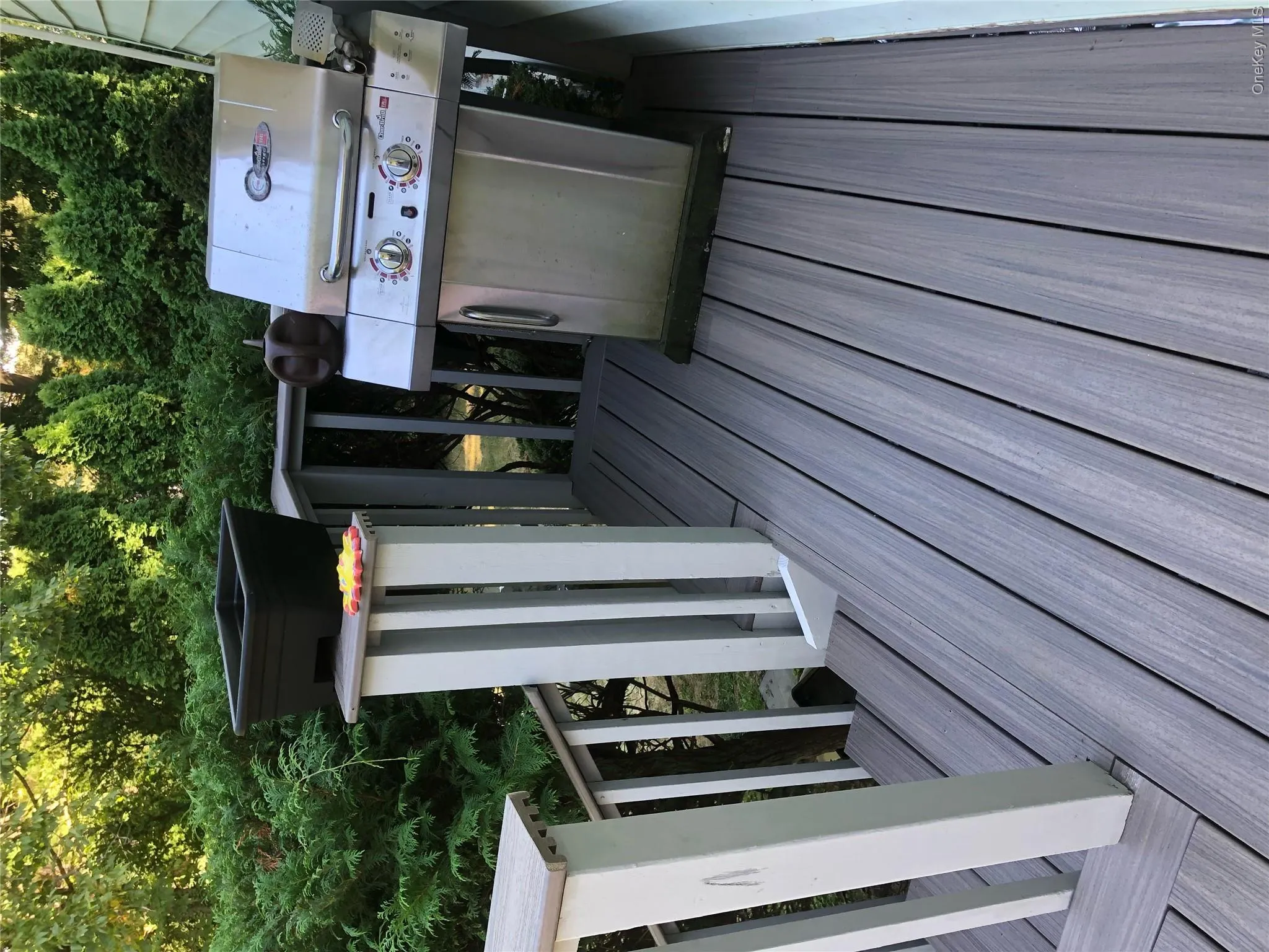 Wooden terrace featuring a grill Wooden terrace featuring a grill