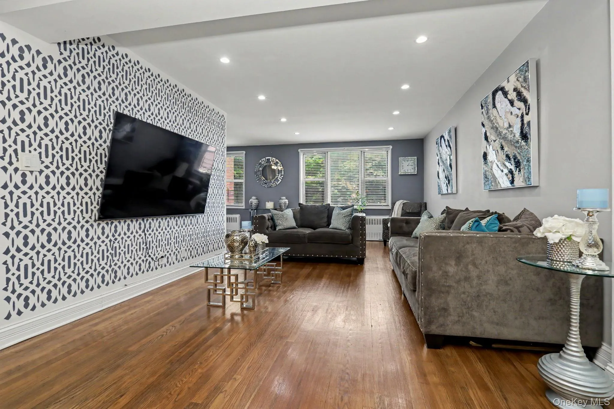 Hardwood flooring, recessed lighting, patterned accent wall, multiple windows, and a built-in wall niche Hardwood flooring, recessed lighting, patterned accent wall, multiple windows, and a built-in wall niche
