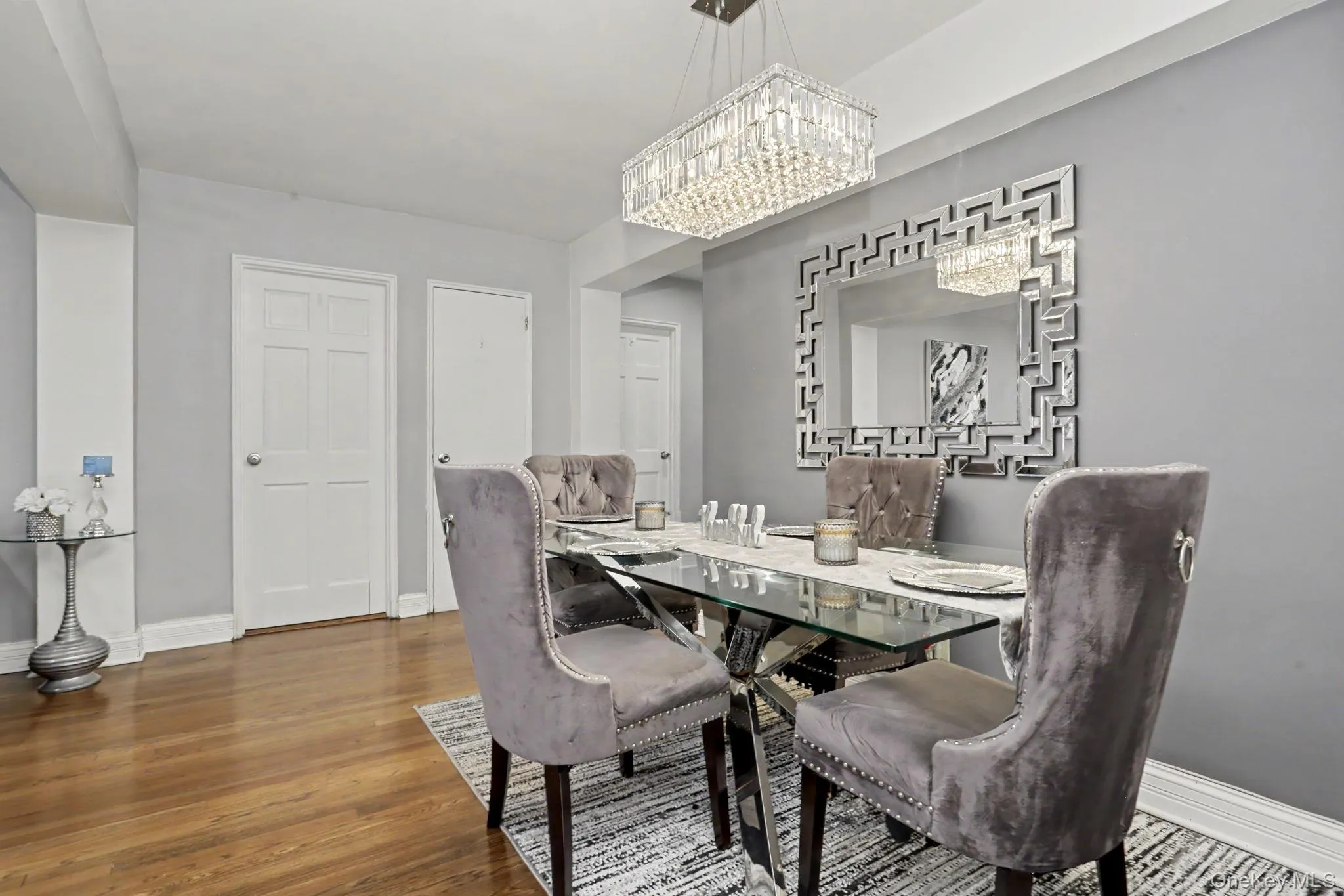 Hardwood flooring throughout, with a rectangular crystal chandelier, and a decorative wall mirror Hardwood flooring throughout, with a rectangular crystal chandelier, and a decorative wall mirror