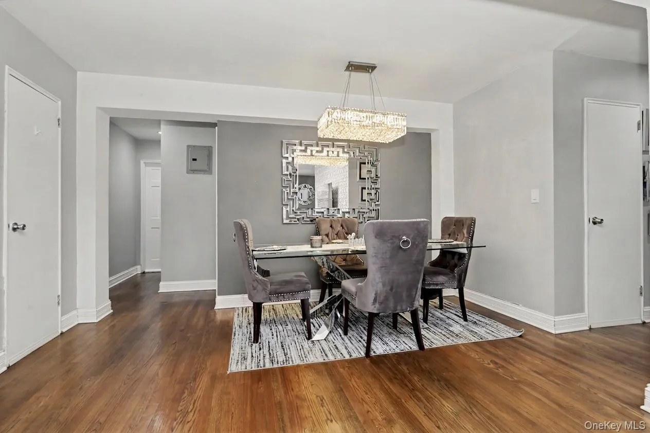 Wood-finish flooring throughout, recessed dining area, and a rectangular crystal chandelier Wood-finish flooring throughout, recessed dining area, and a rectangular crystal chandelier