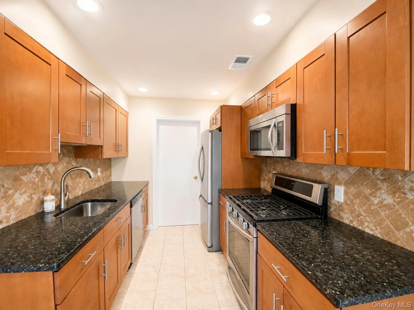 Kitchen with granite counters and stainless steel appliances. Kitchen with granite counters and stainless steel appliances.