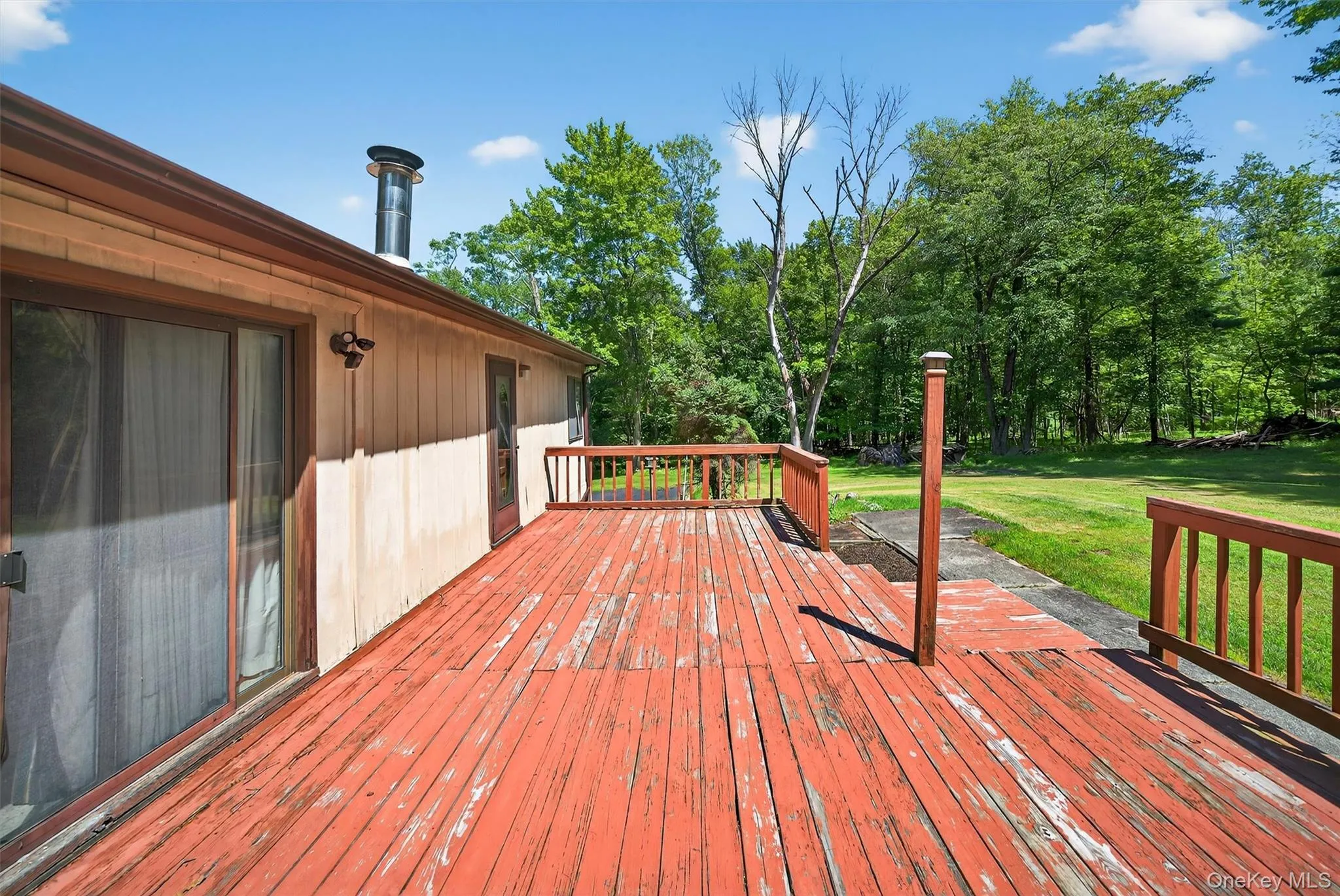 Wooden deck featuring a lawn Wooden deck featuring a lawn