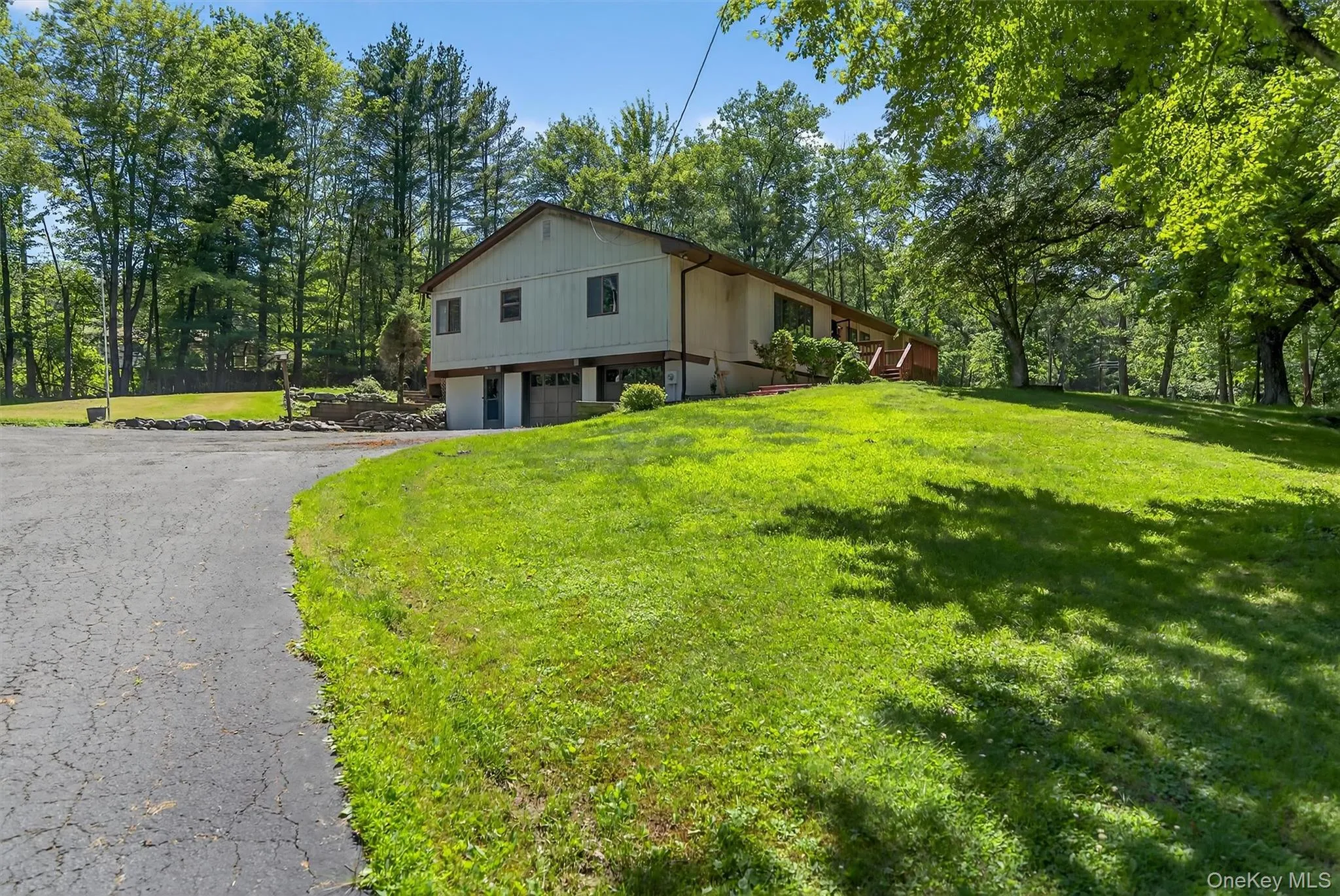 View of home's exterior featuring an attached garage, driveway, and a yard View of home's exterior featuring an attached garage, driveway, and a yard