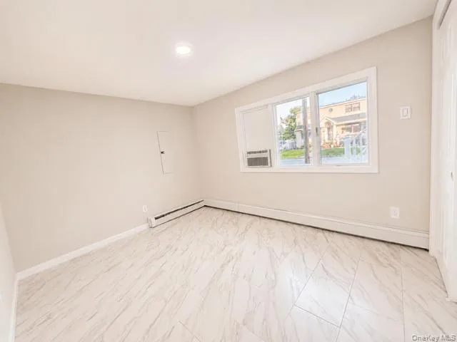 Bright, newly finished room with light wood-finish flooring, recessed ceiling lighting, and large casement windows providing natural light Bright, newly finished room with light wood-finish flooring, recessed ceiling lighting, and large casement windows providing natural light