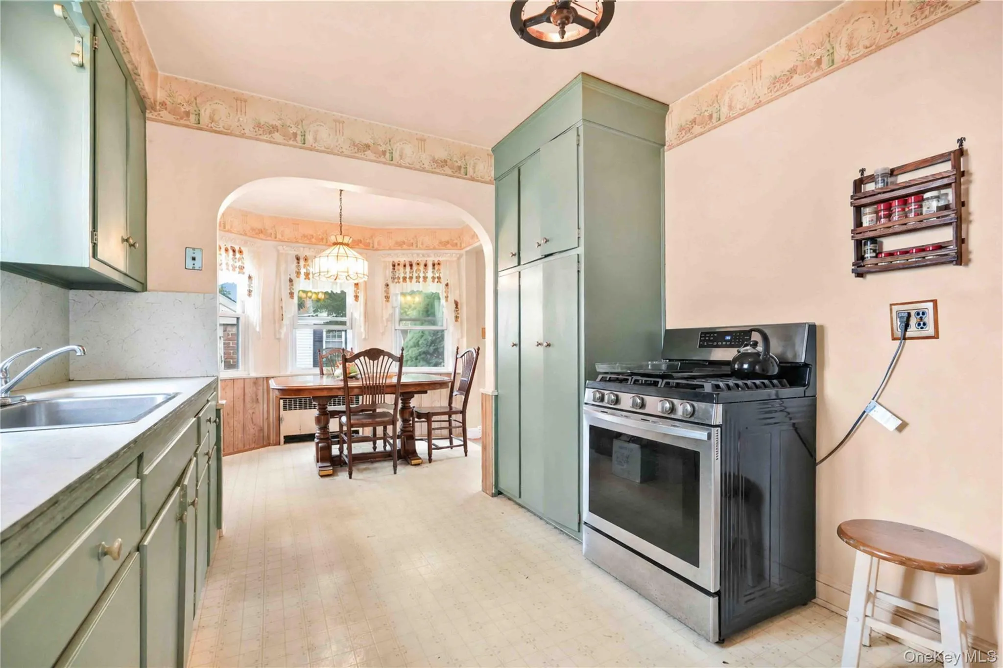 Kitchen featuring built-in cabinetry, stainless steel range, and vinyl flooring Kitchen featuring built-in cabinetry, stainless steel range, and vinyl flooring