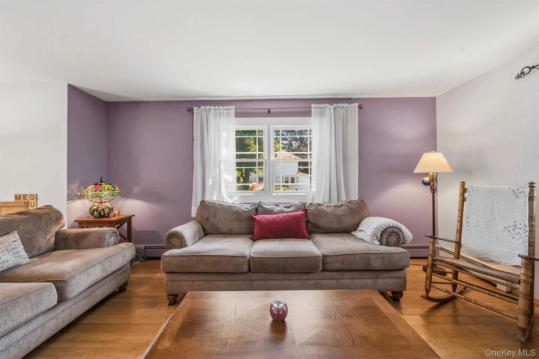 Hardwood-style flooring, a double-hung window, and a painted accent wall Hardwood-style flooring, a double-hung window, and a painted accent wall