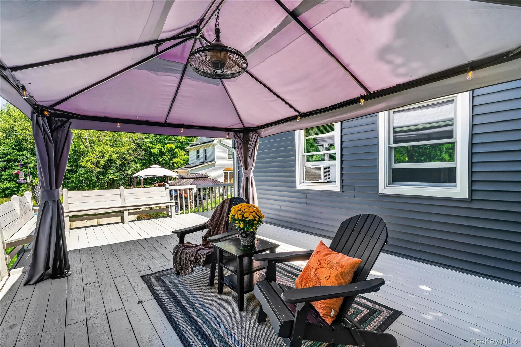 Covered deck with a gazebo structure, wood-plank flooring, and built-in benches Covered deck with a gazebo structure, wood-plank flooring, and built-in benches
