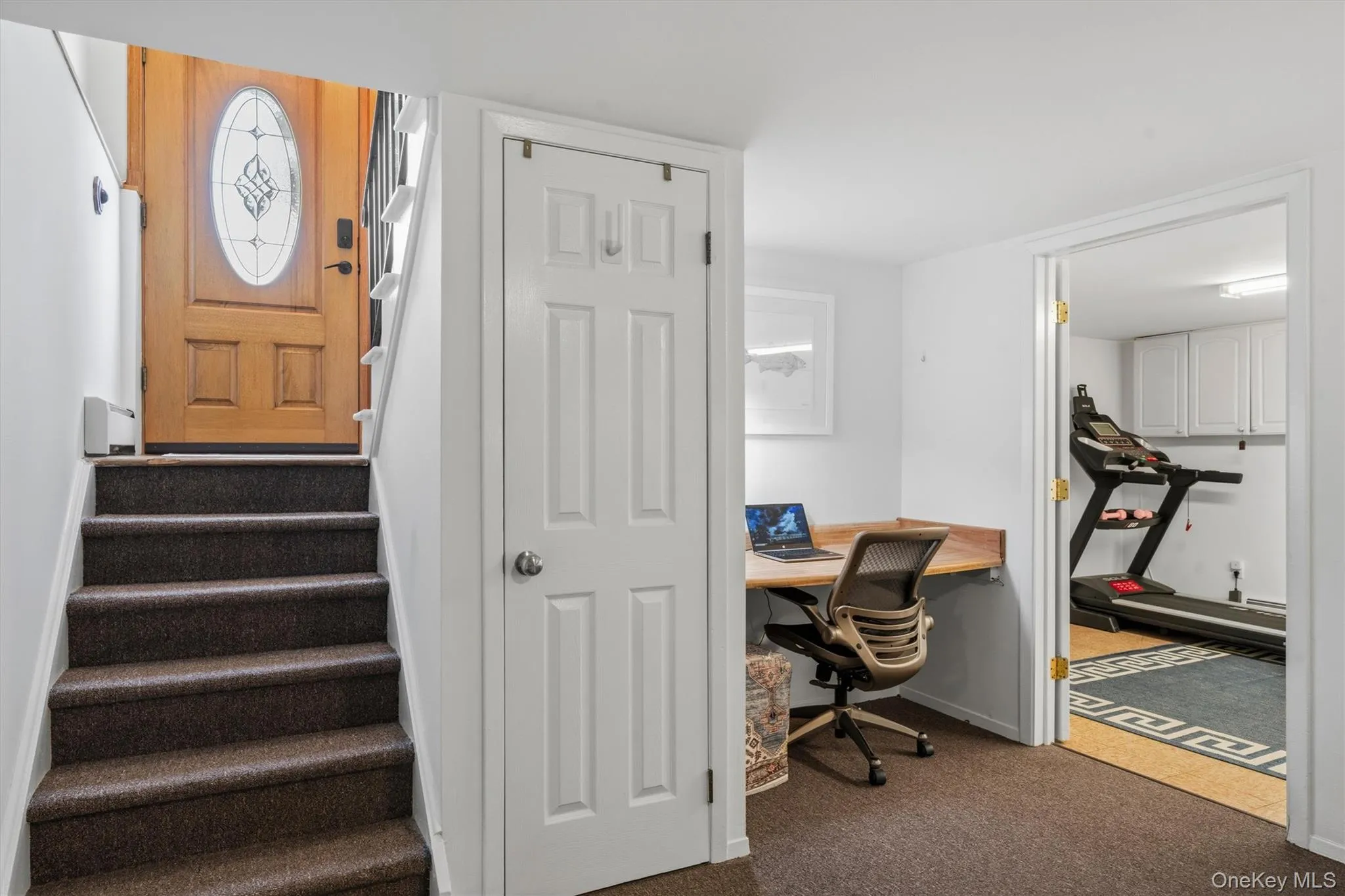 Entrance door leading to lower level. With under stair storage, workstation and entrance to the oversized laundry room Entrance door leading to lower level. With under stair storage, workstation and entrance to the oversized laundry room