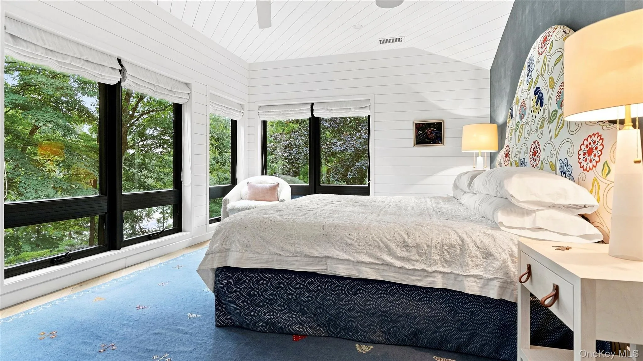 Private top-floor primary bedroom with a wall of windows and treetop views Private top-floor primary bedroom with a wall of windows and treetop views