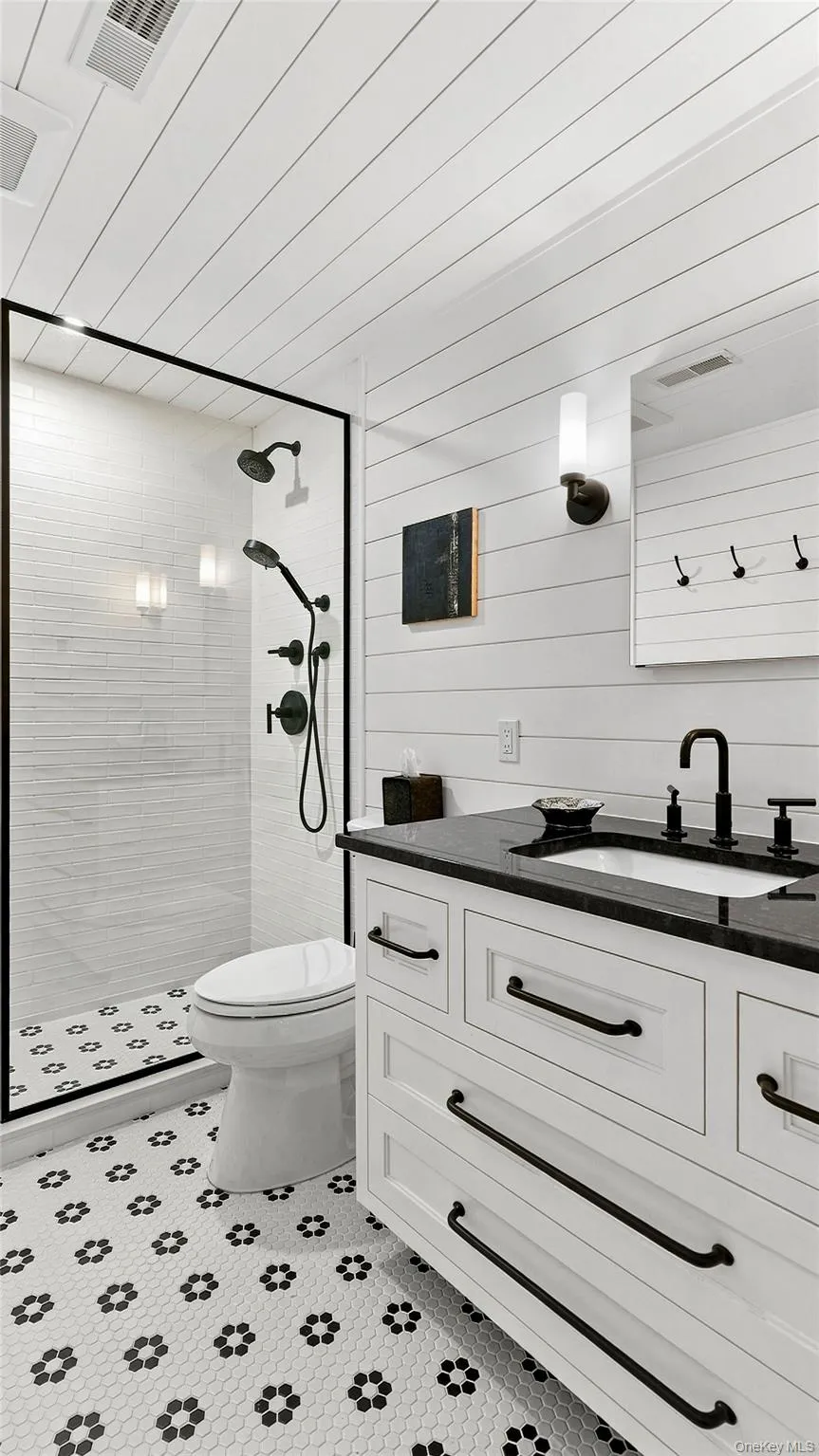 Crisp, beautifully appointed full bath with custom vanity and distinctive tilework. Crisp, beautifully appointed full bath with custom vanity and distinctive tilework.