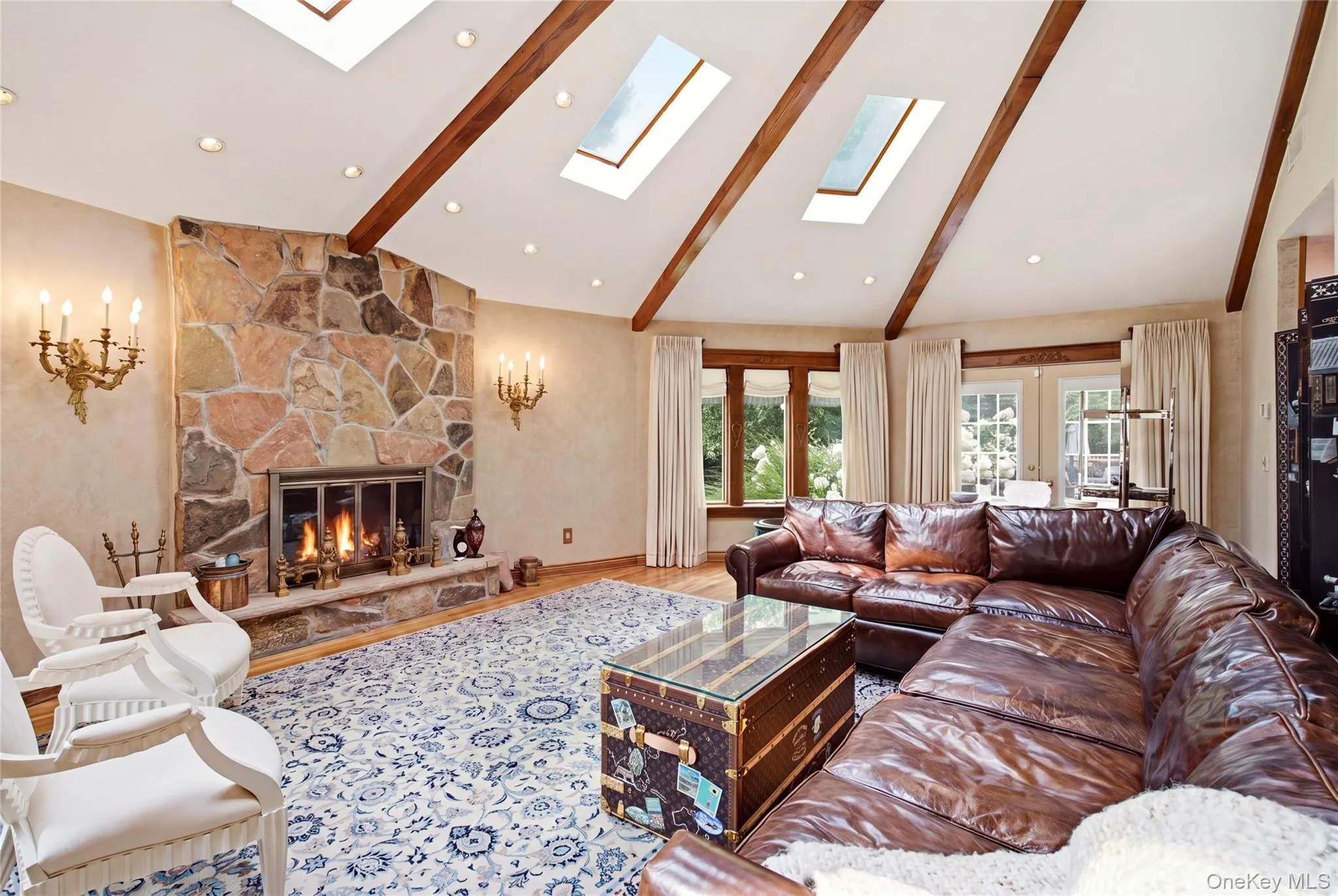 Vaulted ceiling with exposed wood beams, skylights, recessed lighting, and hardwood flooring Vaulted ceiling with exposed wood beams, skylights, recessed lighting, and hardwood flooring