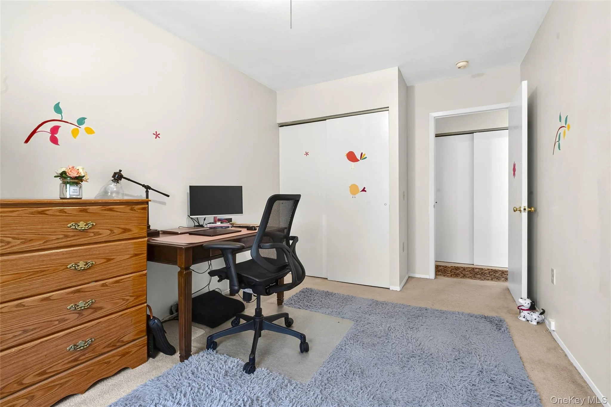 Wall-to-wall carpeting, wood-finish dresser, built-in closet with sliding doors, and an additional doorway Wall-to-wall carpeting, wood-finish dresser, built-in closet with sliding doors, and an additional doorway