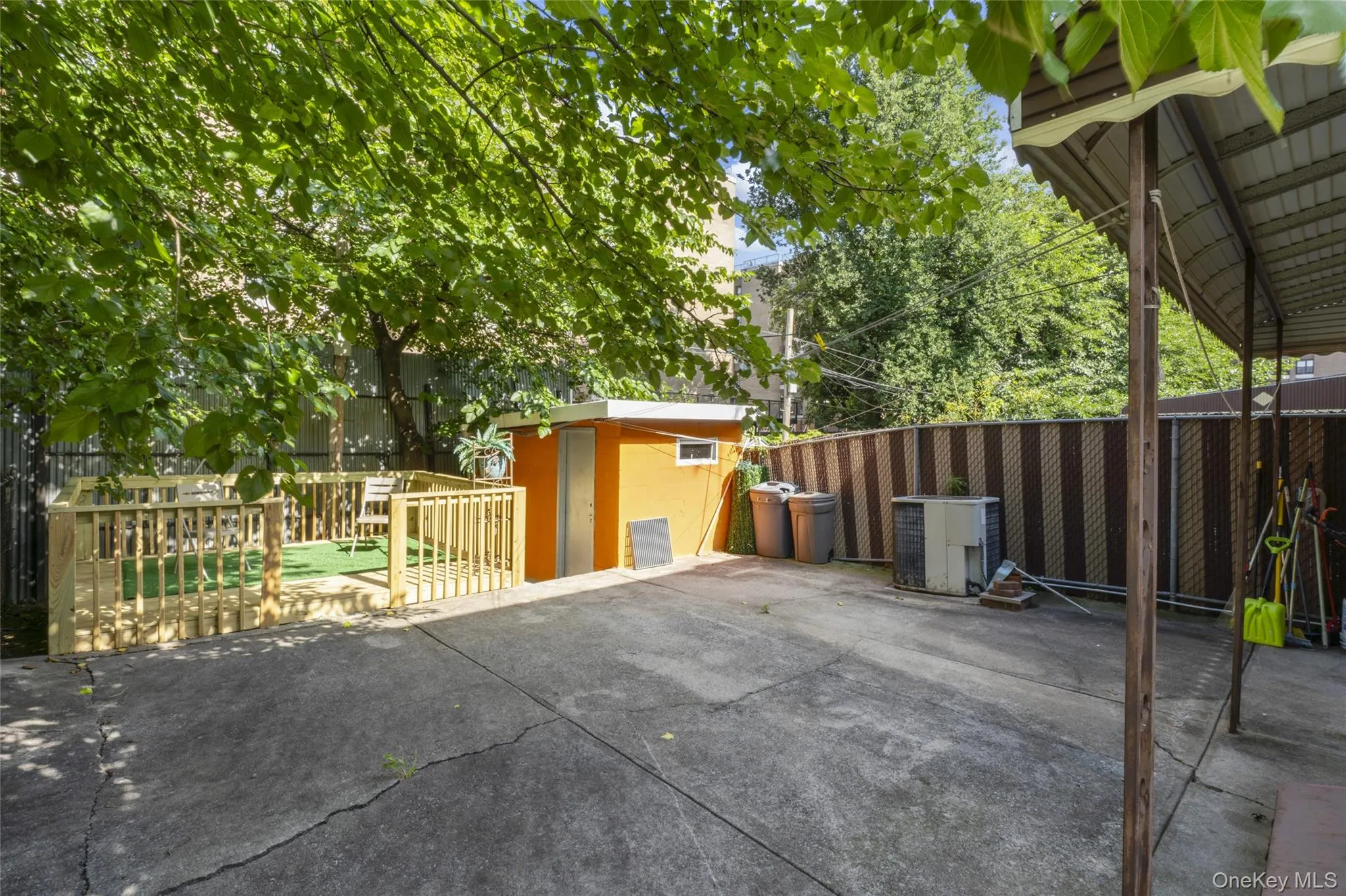 Paved backyard with deck and shed Paved backyard with deck and shed