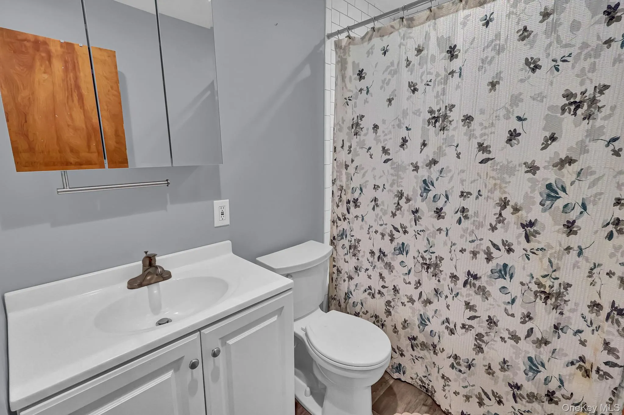 White vanity with integrated sink, mounted medicine cabinet, and a chrome towel bar White vanity with integrated sink, mounted medicine cabinet, and a chrome towel bar