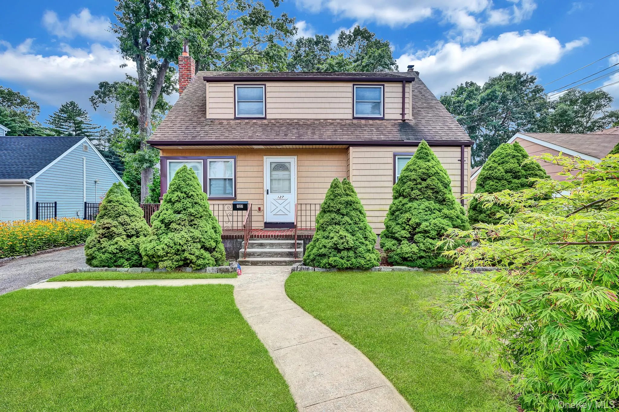 Siding exterior, gabled roof, front porch with railings, concrete walkway, and manicured lawn Siding exterior, gabled roof, front porch with railings, concrete walkway, and manicured lawn