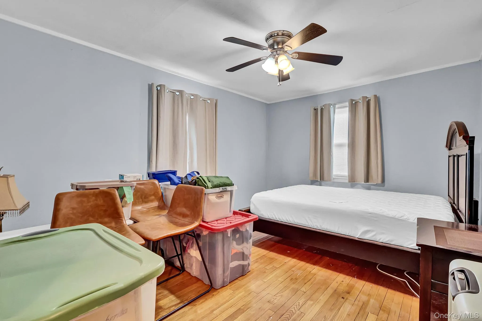 Hardwood flooring, light blue wall paint, ceiling fan with light fixture, and window with trim Hardwood flooring, light blue wall paint, ceiling fan with light fixture, and window with trim