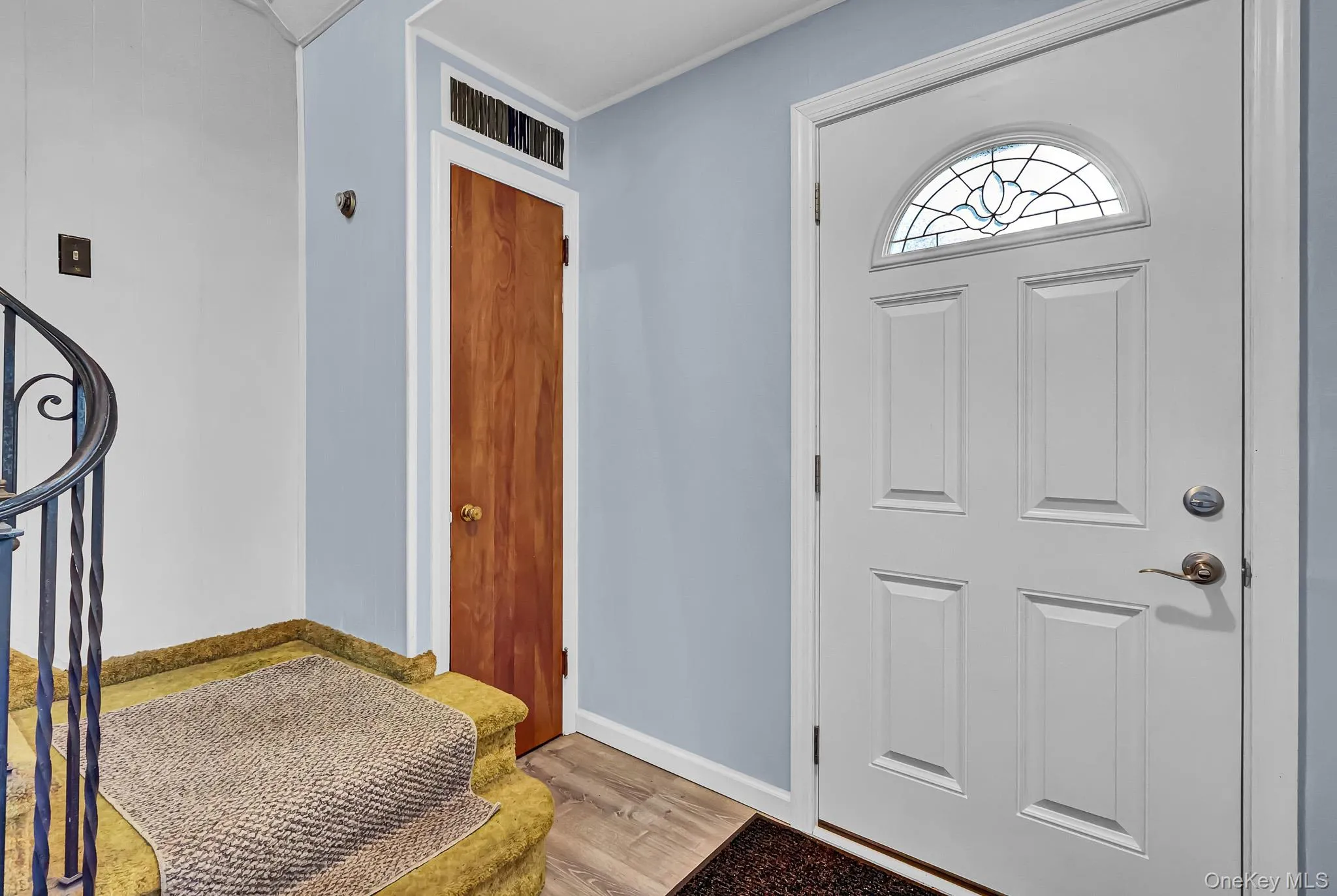 Entry door with decorative arched glass insert, paneled design, and brushed nickel hardware Entry door with decorative arched glass insert, paneled design, and brushed nickel hardware