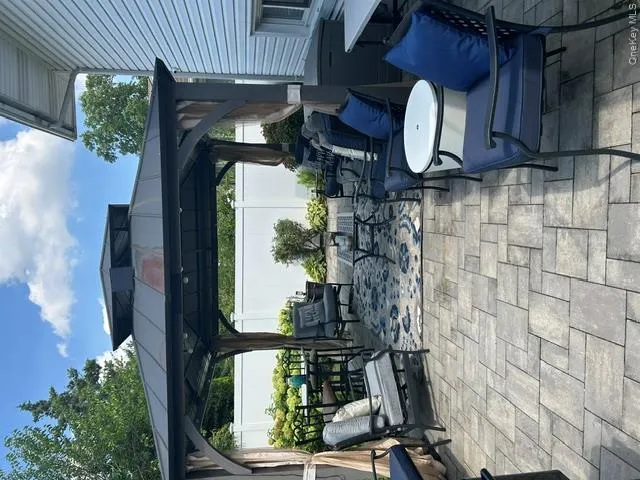 Paver patio with a permanent gazebo structure, featuring a privacy fence and exterior siding Paver patio with a permanent gazebo structure, featuring a privacy fence and exterior siding