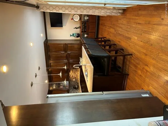 Kitchen featuring wood-finish flooring, recessed lighting, pendant lighting, built-in cabinetry, and a center island with a built-in sink Kitchen featuring wood-finish flooring, recessed lighting, pendant lighting, built-in cabinetry, and a center island with a built-in sink