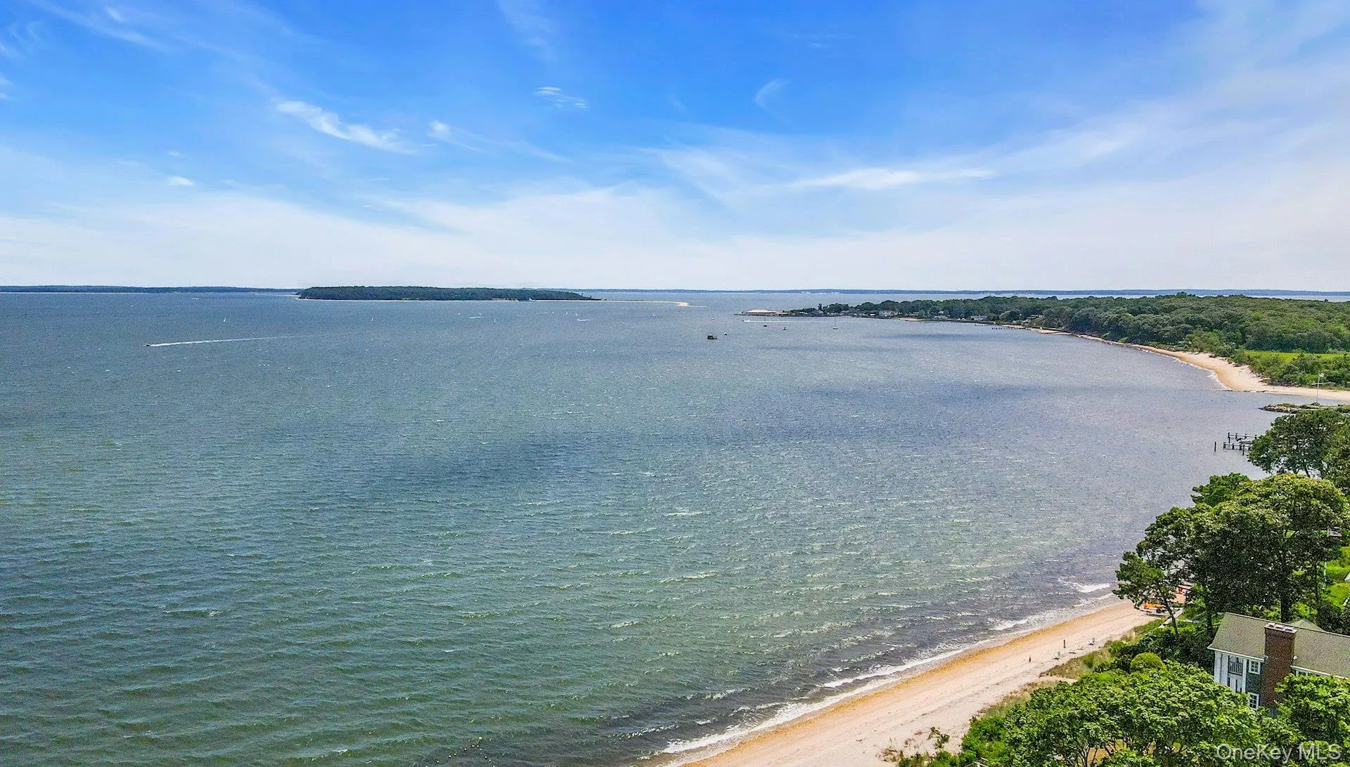 Expansive waterfront with a sandy beach and a distant island Expansive waterfront with a sandy beach and a distant island