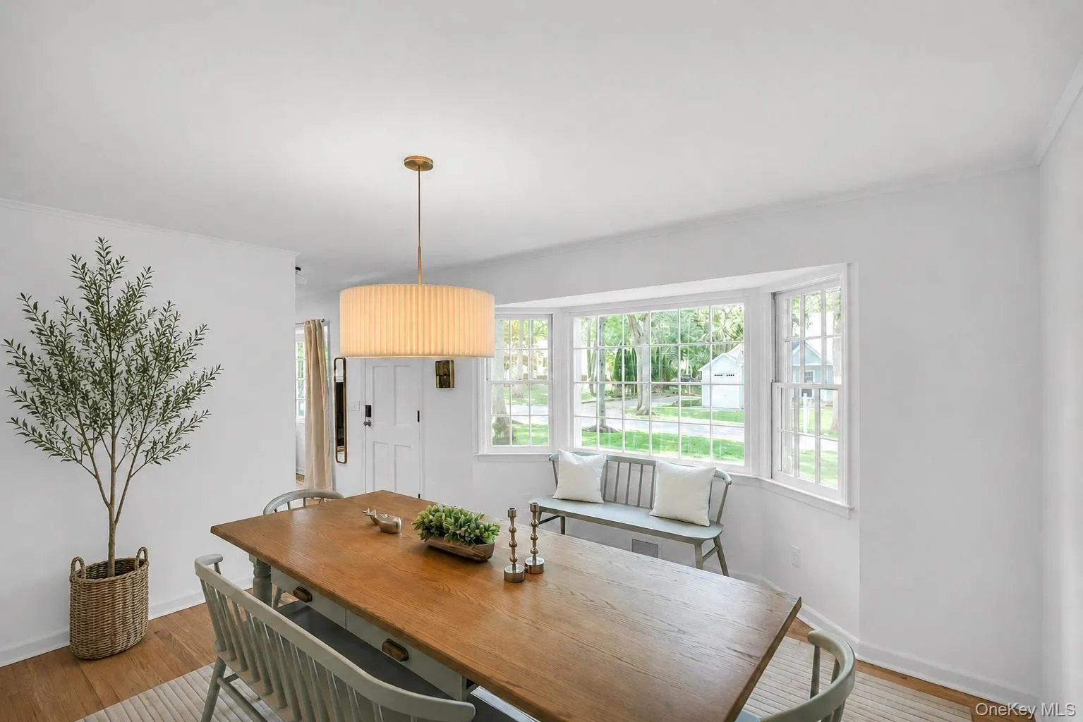 Hardwood-finish flooring, white walls, and a large bay window Hardwood-finish flooring, white walls, and a large bay window