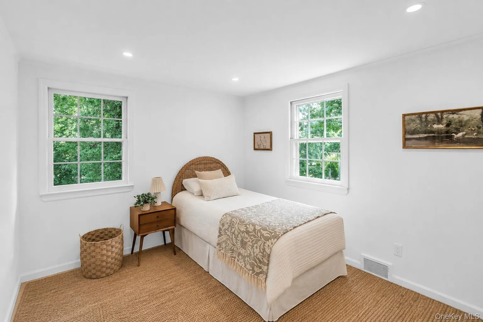 Recessed lighting illuminates a room with two large windows and a woven area rug Recessed lighting illuminates a room with two large windows and a woven area rug