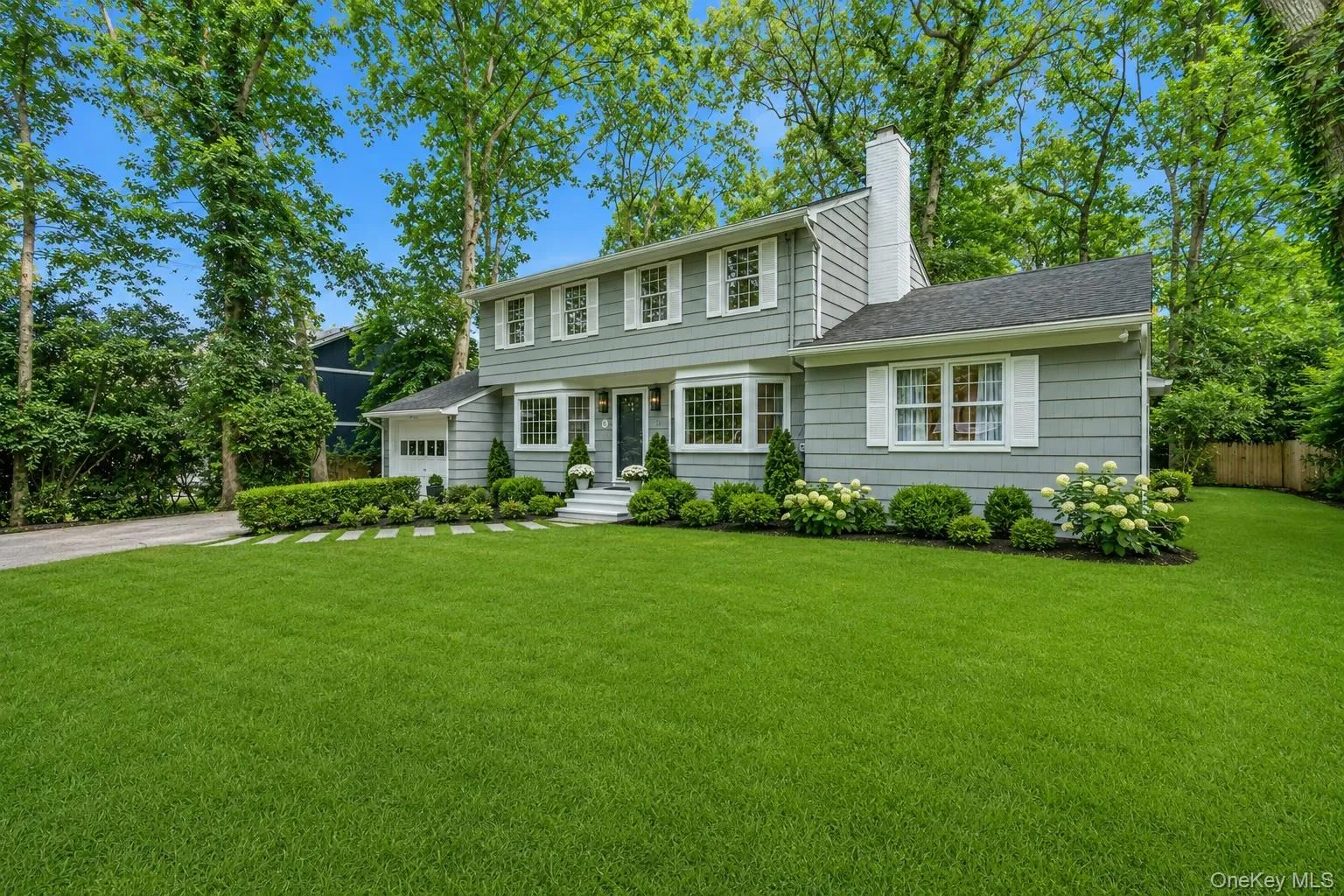 Two-story residence featuring grey wood and white window shutters Two-story residence featuring grey wood and white window shutters