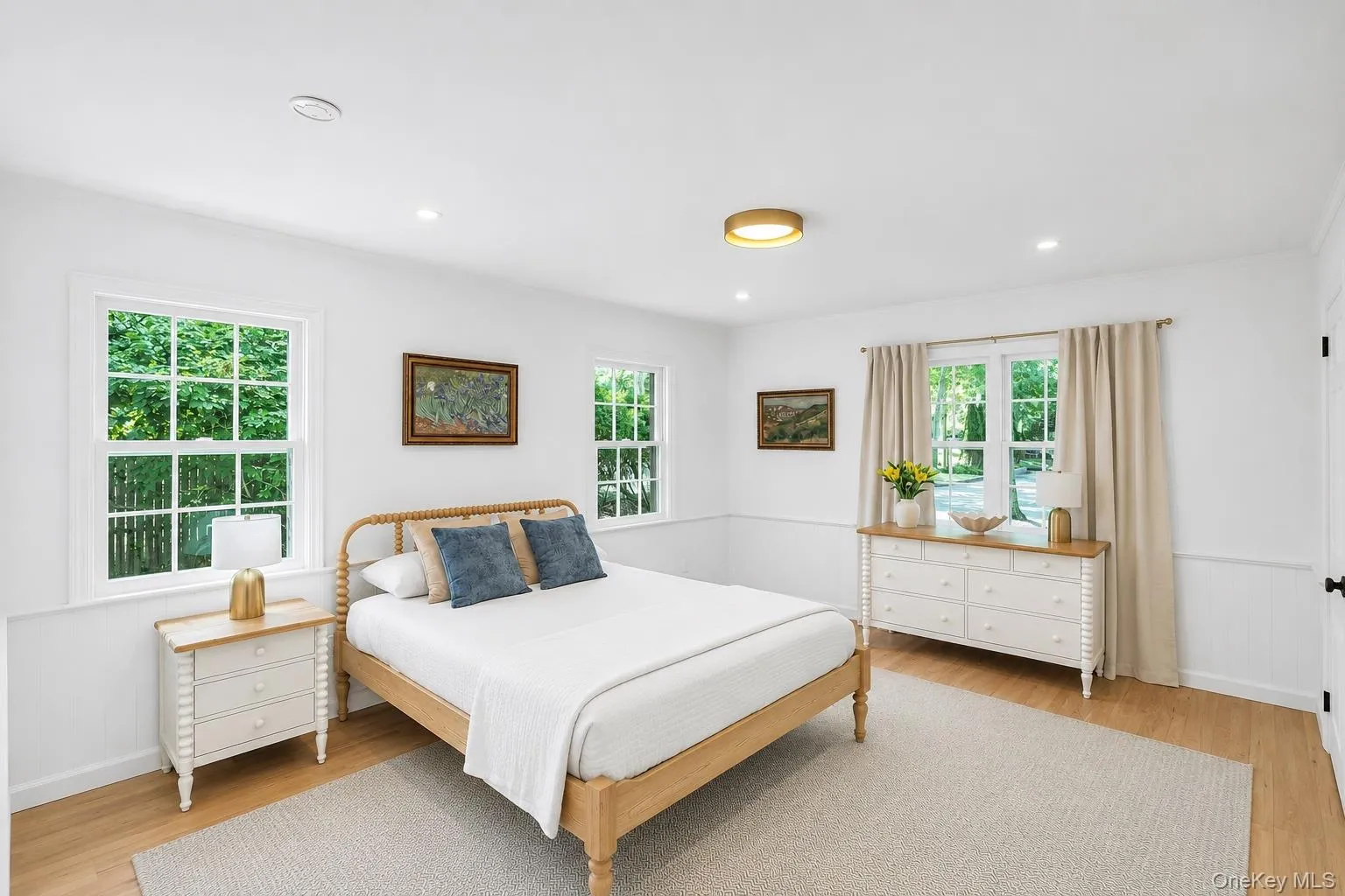 Wood-finish flooring, recessed lighting, and a circular flush-mount ceiling fixture Wood-finish flooring, recessed lighting, and a circular flush-mount ceiling fixture