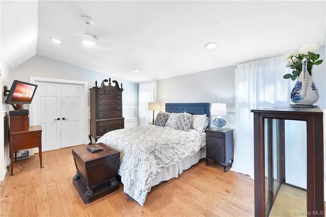 Bedroom featuring a closet, lofted ceiling, light wood-type flooring, and ceiling fan Bedroom featuring a closet, lofted ceiling, light wood-type flooring, and ceiling fan