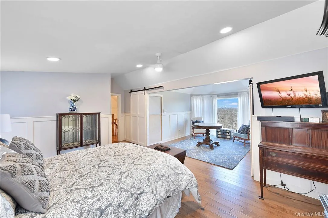 Bedroom with lofted ceiling, a barn door, and hardwood / wood-style flooring Bedroom with lofted ceiling, a barn door, and hardwood / wood-style flooring